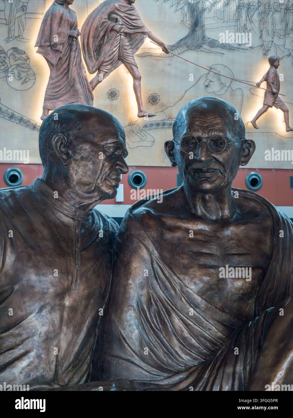 Interno spazioso dell'aeroporto di Ahmedabad in India con una scultura prominente in primo piano, con banconi di check-in e arte murale decorativa in t - Immagine stock catturata con smartphone