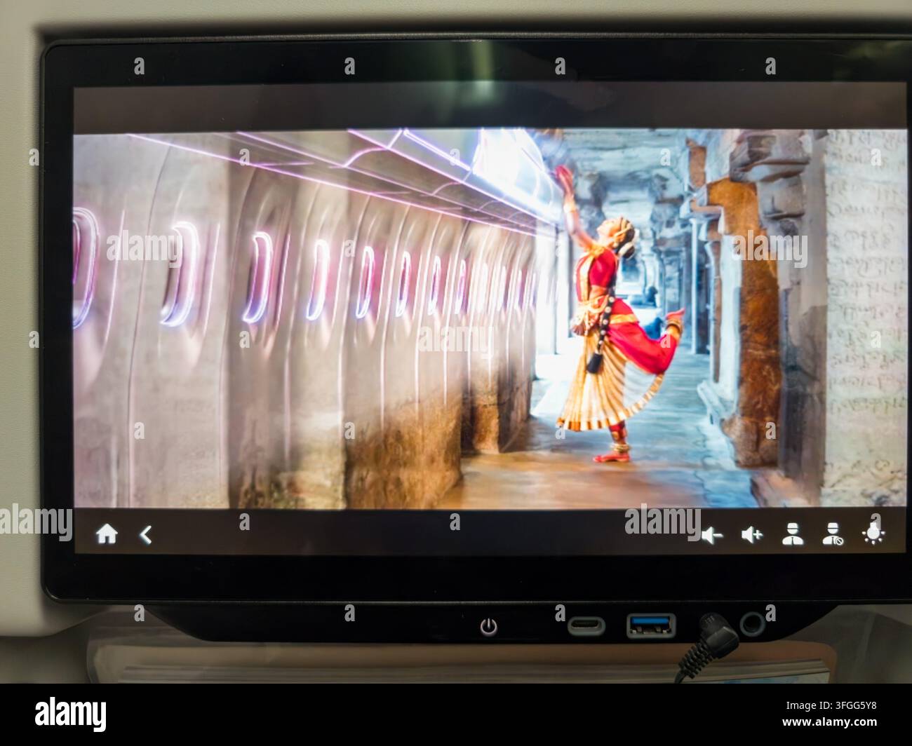 Una vivace rappresentazione della danza tradizionale indiana su uno schermo di intrattenimento in volo a bordo di un aereo Air India. Lo schermo mostra una ballerina in traditi - Immagine stock catturata con smartphone