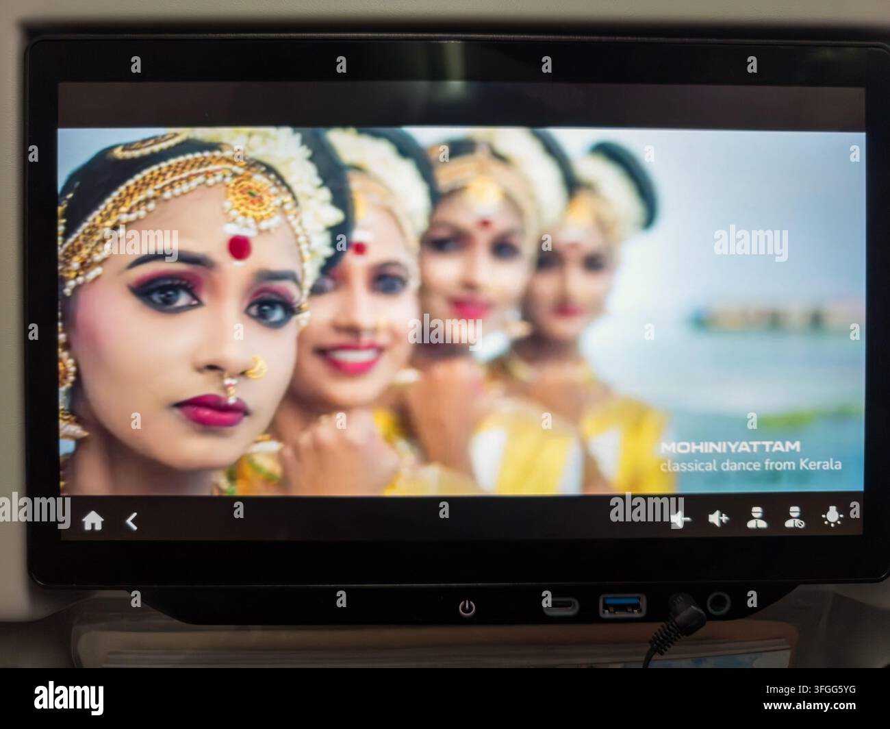 Una vivace rappresentazione della danza tradizionale indiana su uno schermo di intrattenimento in volo a bordo di un aereo Air India. Lo schermo mostra una ballerina in traditi - Immagine stock catturata con smartphone