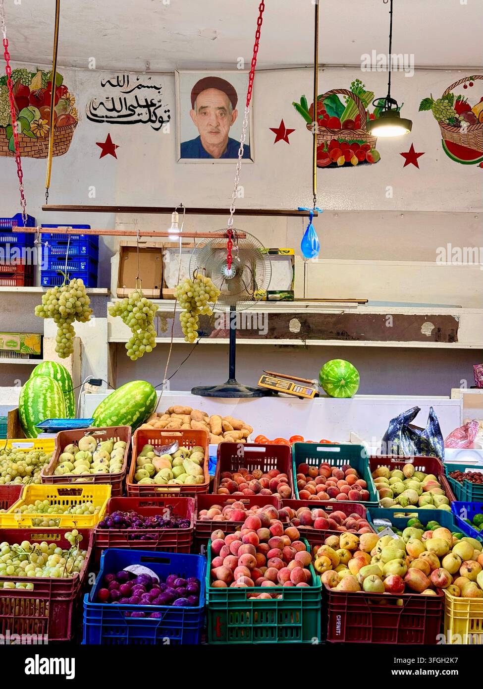 Venditore di frutta e verdura a un colorato banco mercantile nella storica medina di Sousse, Tunisia Foto Stock