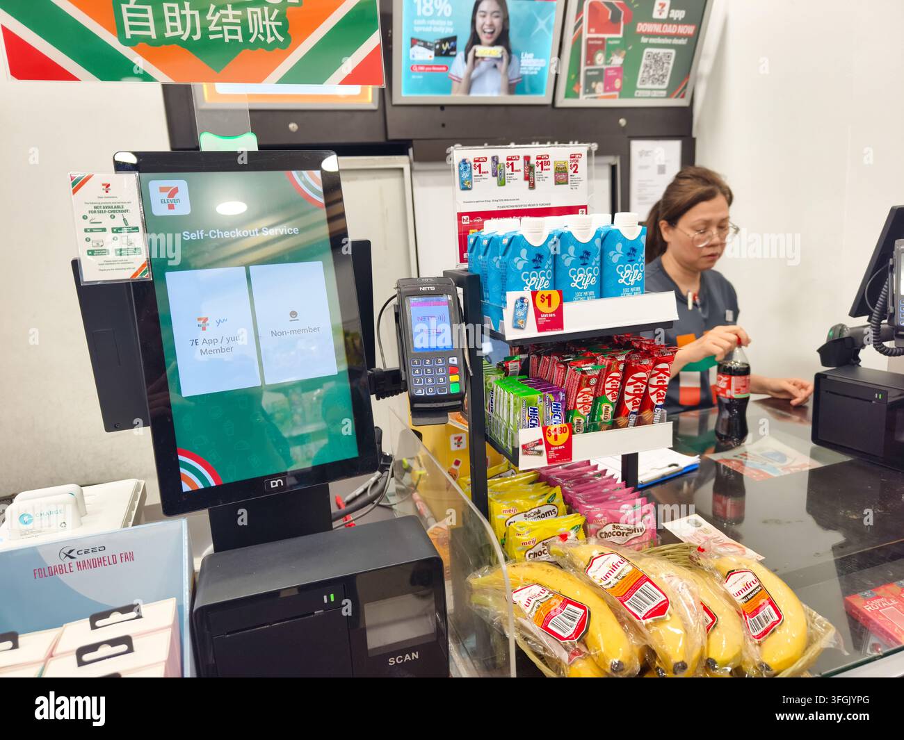 Cassa del negozio di alimentari 7-Eleven dotata di terminale di autoscansione e opzioni di pagamento digitale. Singapore Foto Stock