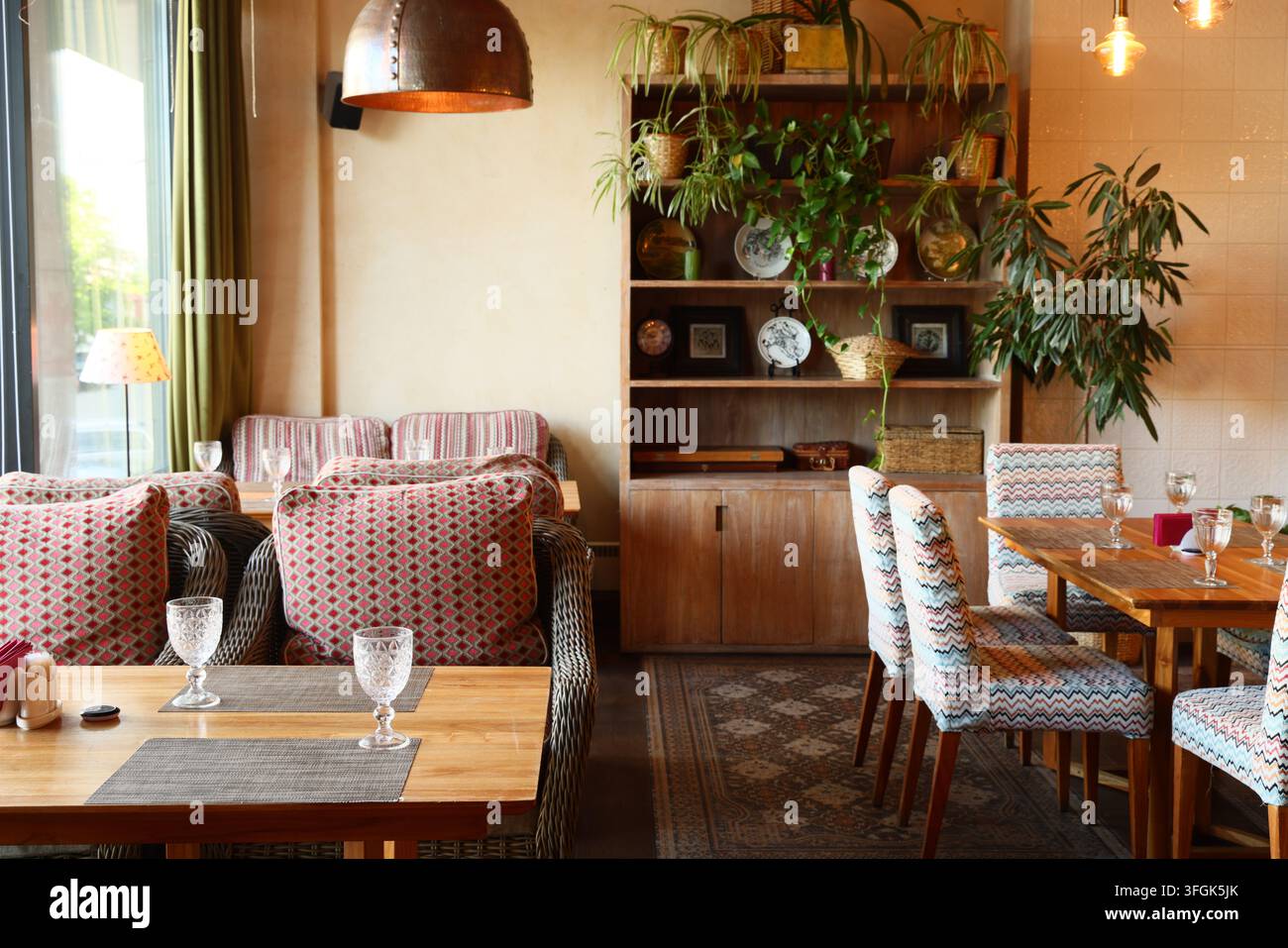 Ambiente luminoso da caffè con piante e aree di lavoro rilassate Foto Stock