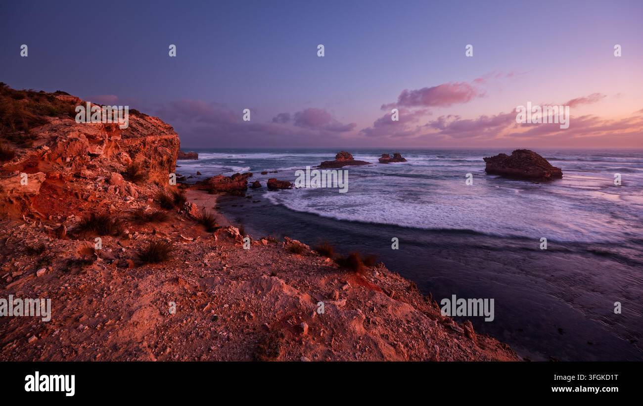 Tramonto sulla spiaggia rocciosa Foto Stock