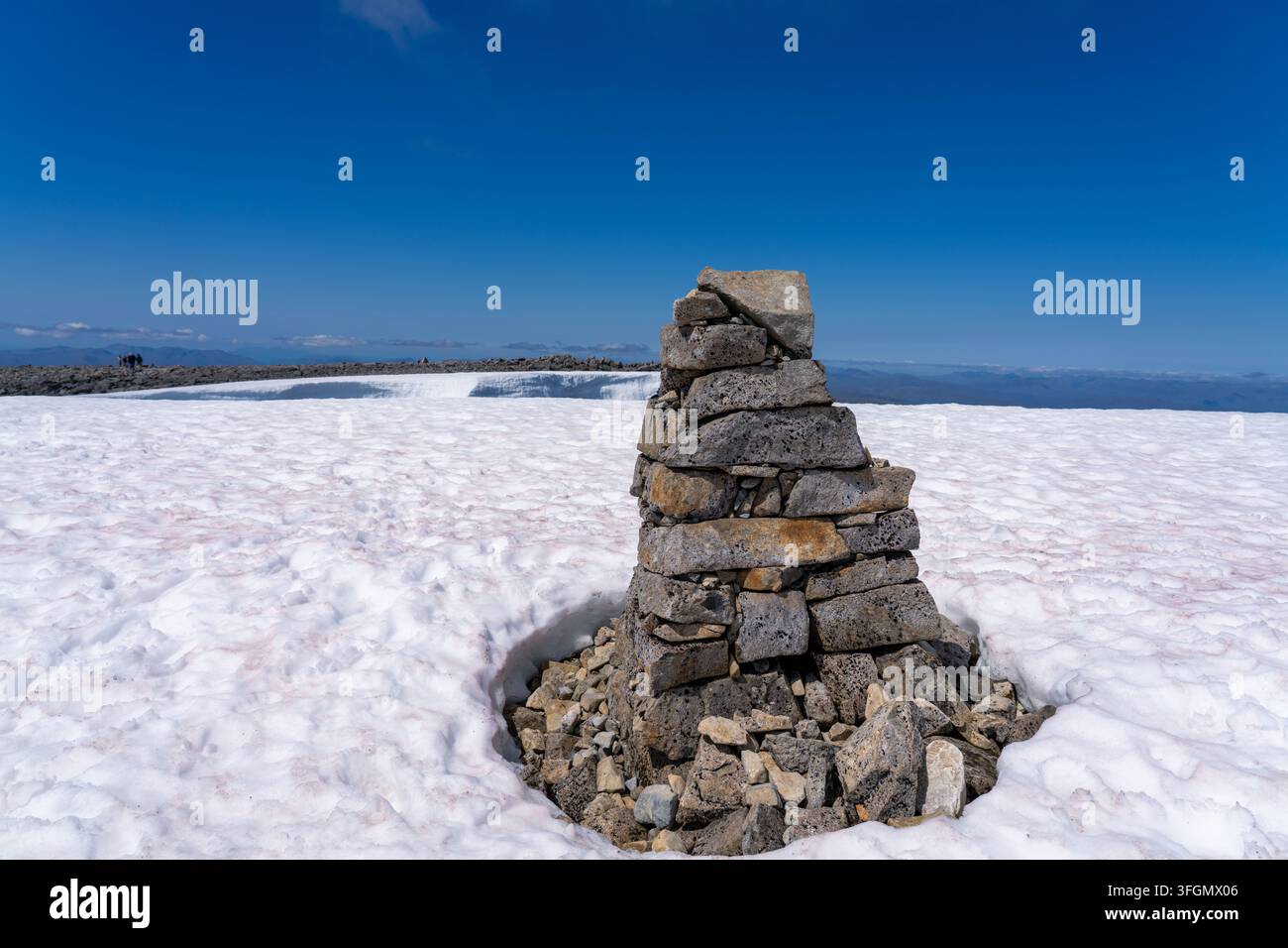 Un cairn sulla vetta innevata del Ben Nevis in Scozia che segna il sentiero per la cima Foto Stock