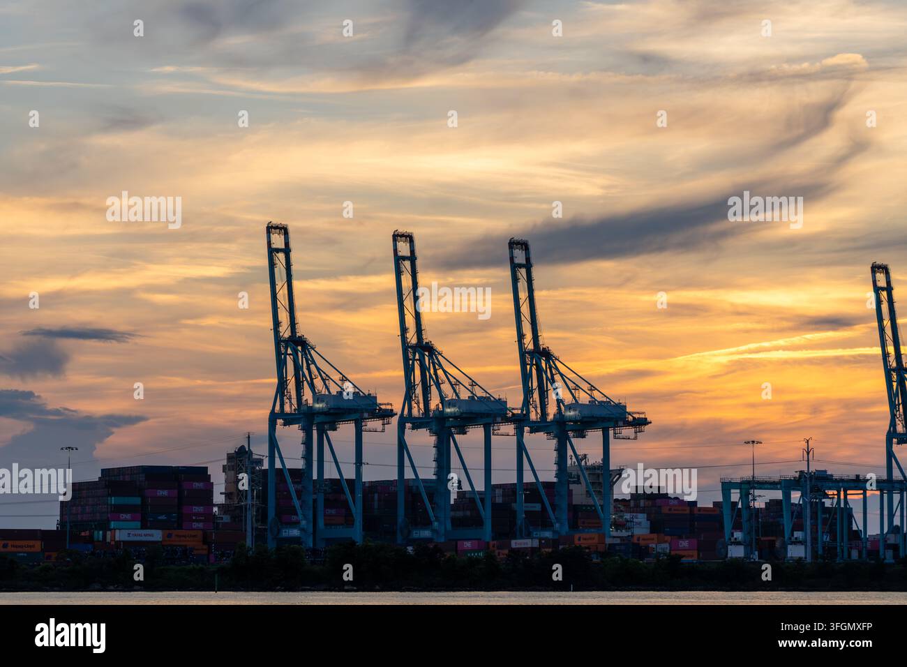 Norfolk Virginia - 4 luglio 2023: Gru e container di spedizione al Terminal Internazionale di Norfolk del Port of Virginia durante il tramonto sul fiume Elizabeth Foto Stock