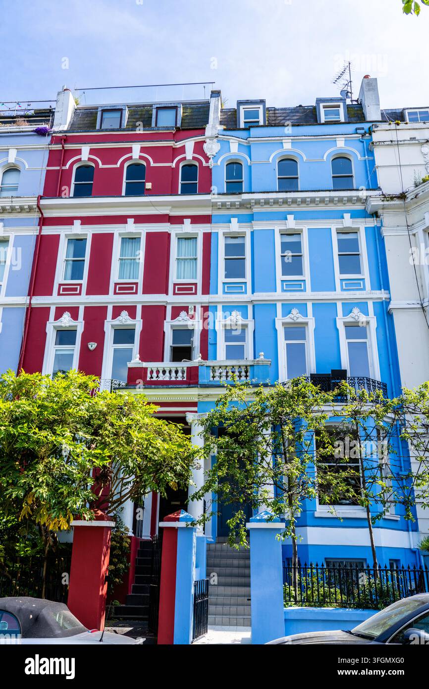 Case a schiera colorate rosse e blu nel quartiere di Notting Hill a Londra, Inghilterra Foto Stock