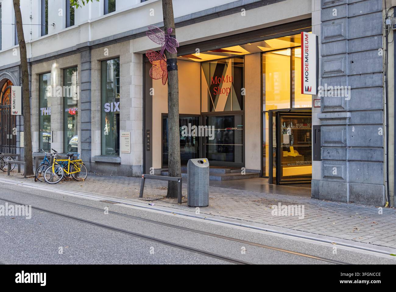 Anversa, Belgio - 06 settembre 2026: Vista esterna della strada dell'ingresso del museo della moda MoMu con biciclette parcheggiate fuori e alberi decorati. Foto Stock