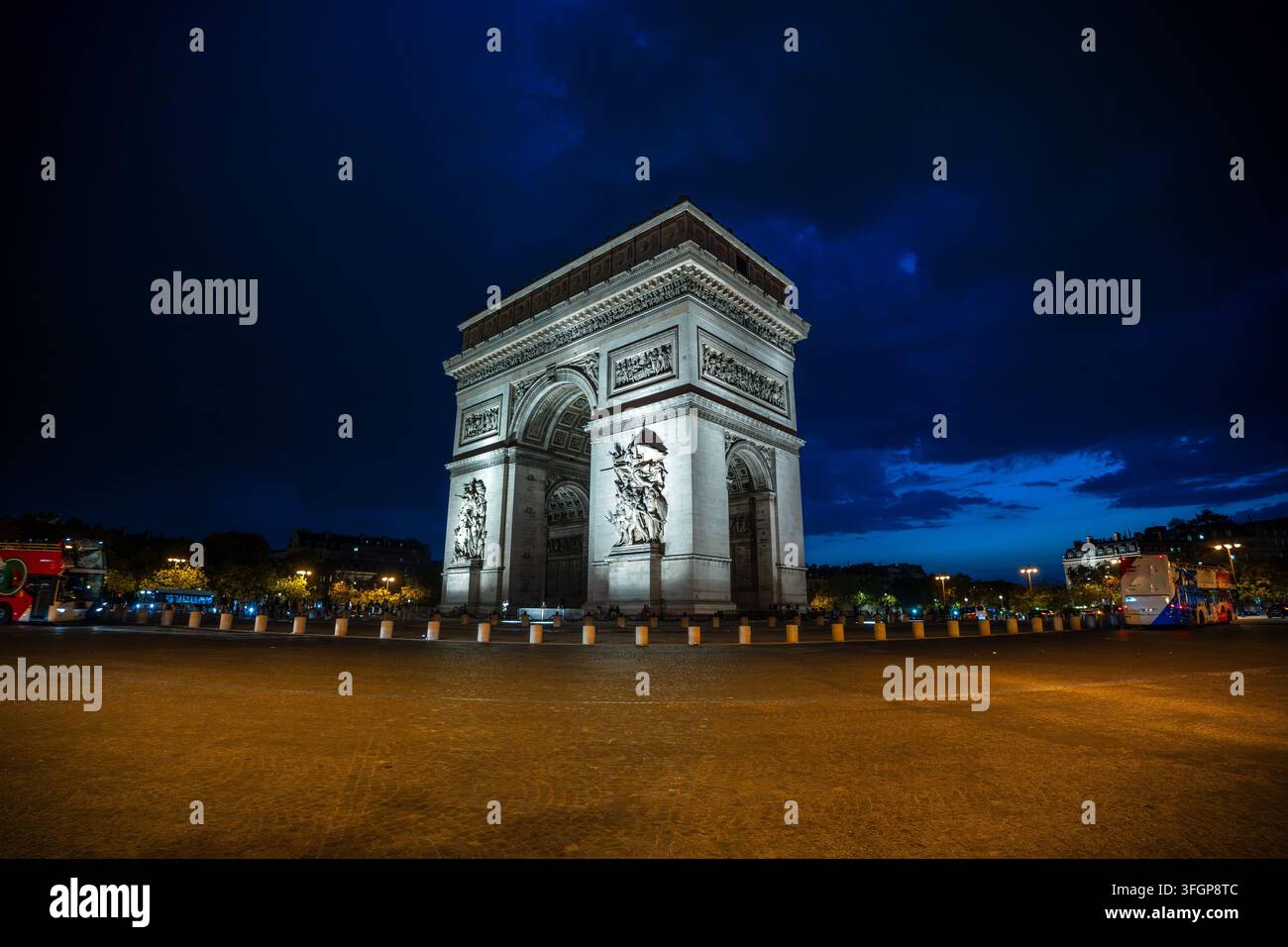 Ampia veduta dell'Arc de Triomphe illuminato sullo sfondo di un cielo blu profondo al crepuscolo in Place Charles de Gaulle a Parigi, Francia. Foto Stock