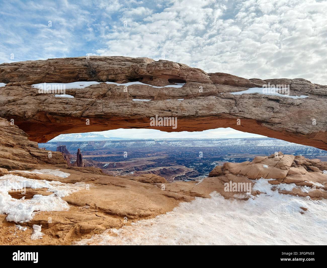 Arco di Mesa innevato che incornicia una vista sul canyon, Parco nazionale di Canyonlands Foto Stock