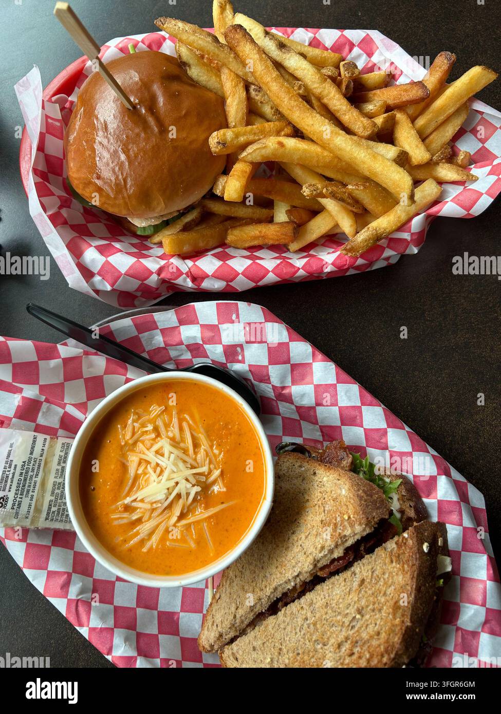 Burger e patatine fritte con zuppa di pomodoro e panino combinati per il pranzo Foto Stock