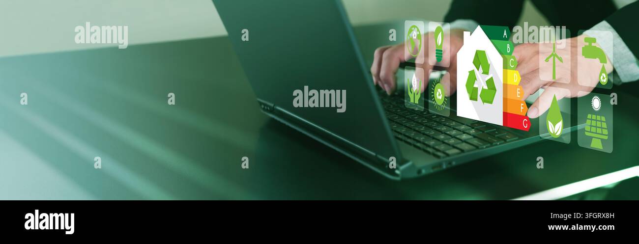Mano che digita su un laptop, icone eco olografiche fluttuano sopra la tastiera. I toni verdi suggeriscono un tema di sostenibilità. Ideale per campagne ambientali o tecnologia- Foto Stock