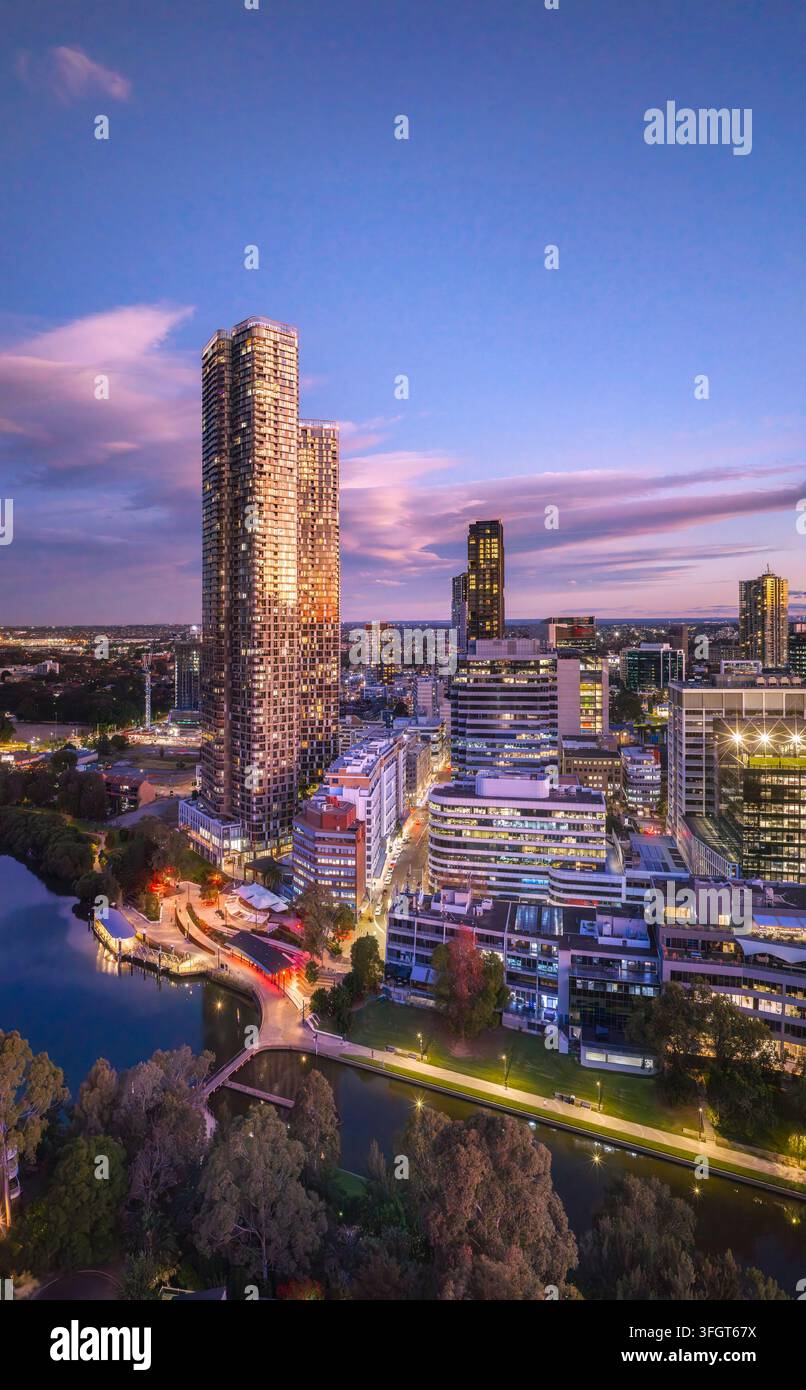 Molo del centro città di Parramatta e grattacieli sul lungofiume al tramonto nella periferia ovest di Sydney – paesaggio urbano verticale aereo. Foto Stock