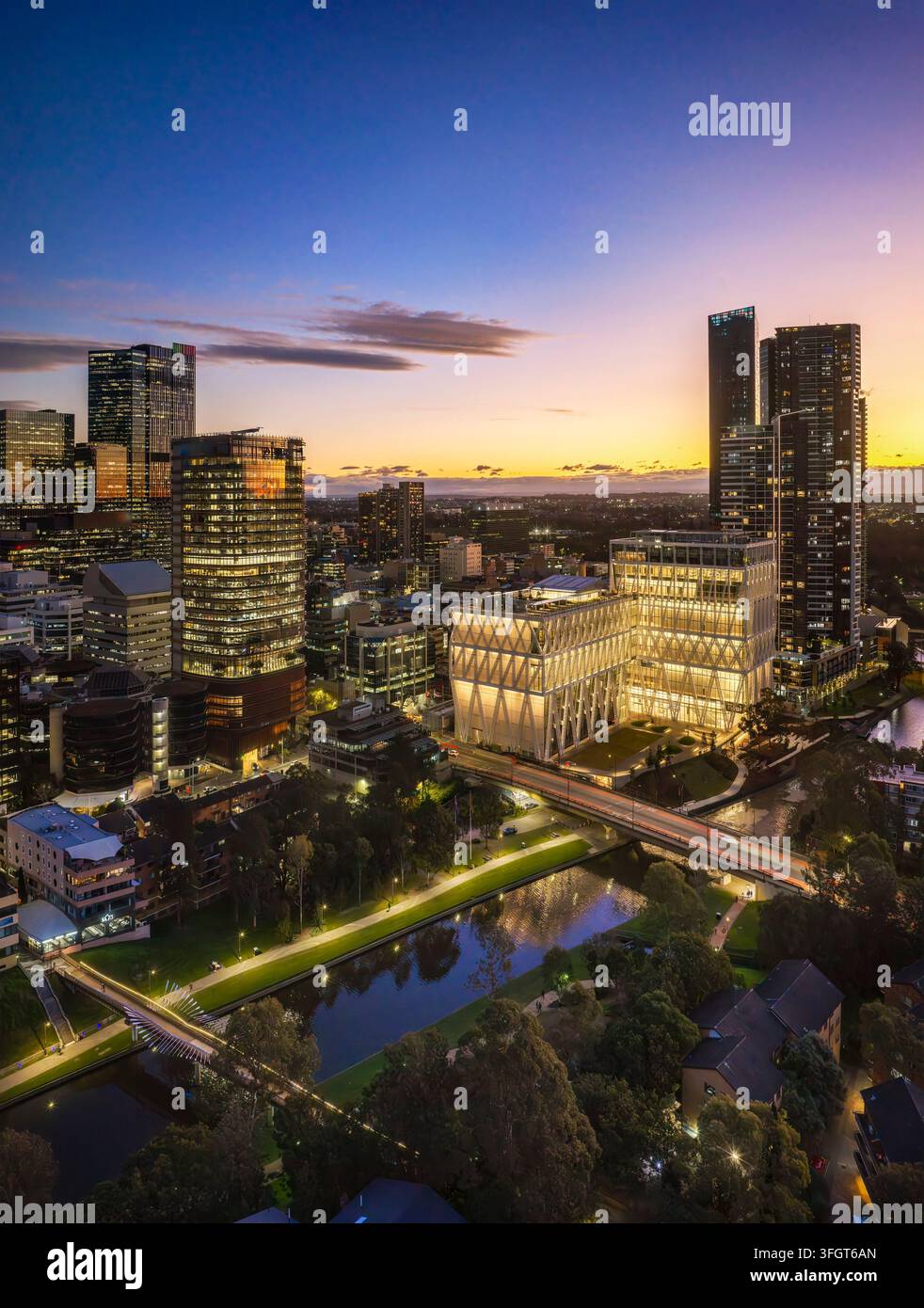 Edificio della centrale elettrica del centro città di Parramatta sul lungofiume al tramonto a Sydney West – paesaggio urbano verticale aereo. Foto Stock