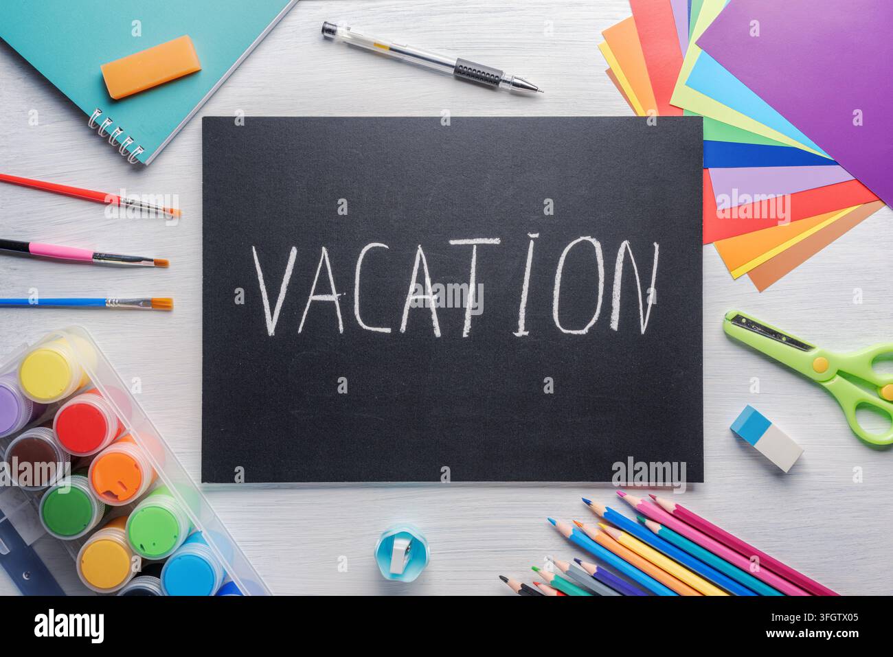 Lavagna con la scritta a gesso: Vacanza. Materiali scolastici Foto Stock