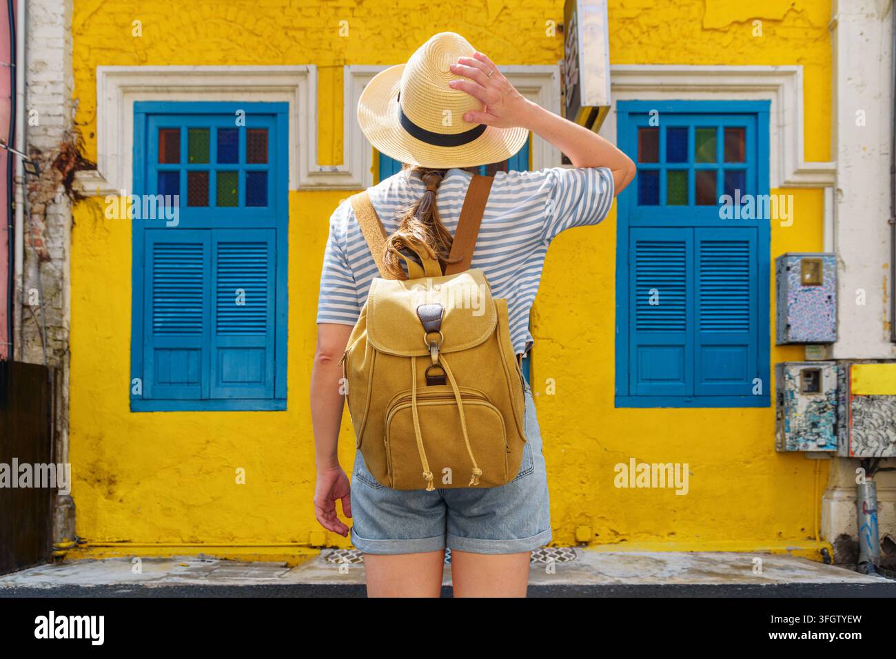 Female tourist is enjoying view of yellow house Foto Stock
