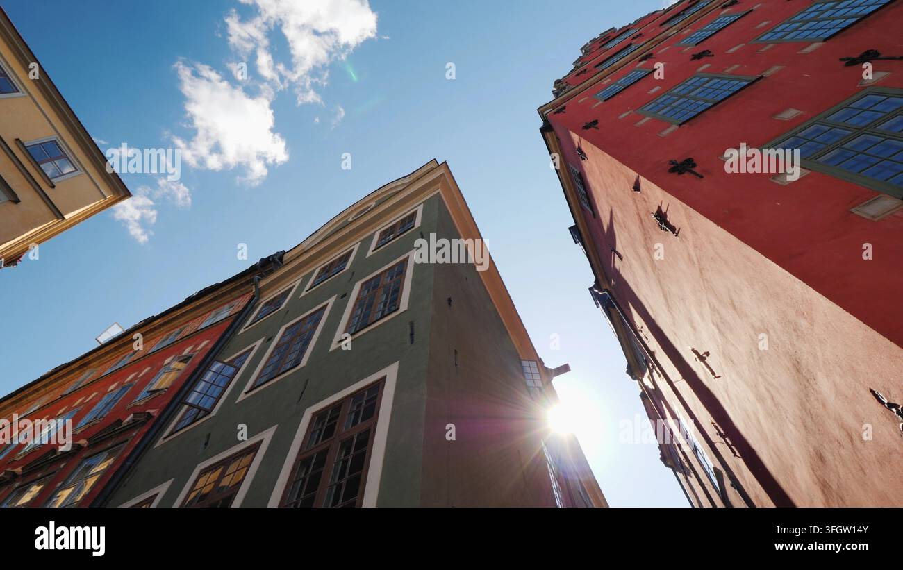 Case vecchie multicolori a Stoccolma. Bella architettura europea, il sole splende da dietro il tetto della casa Foto Stock