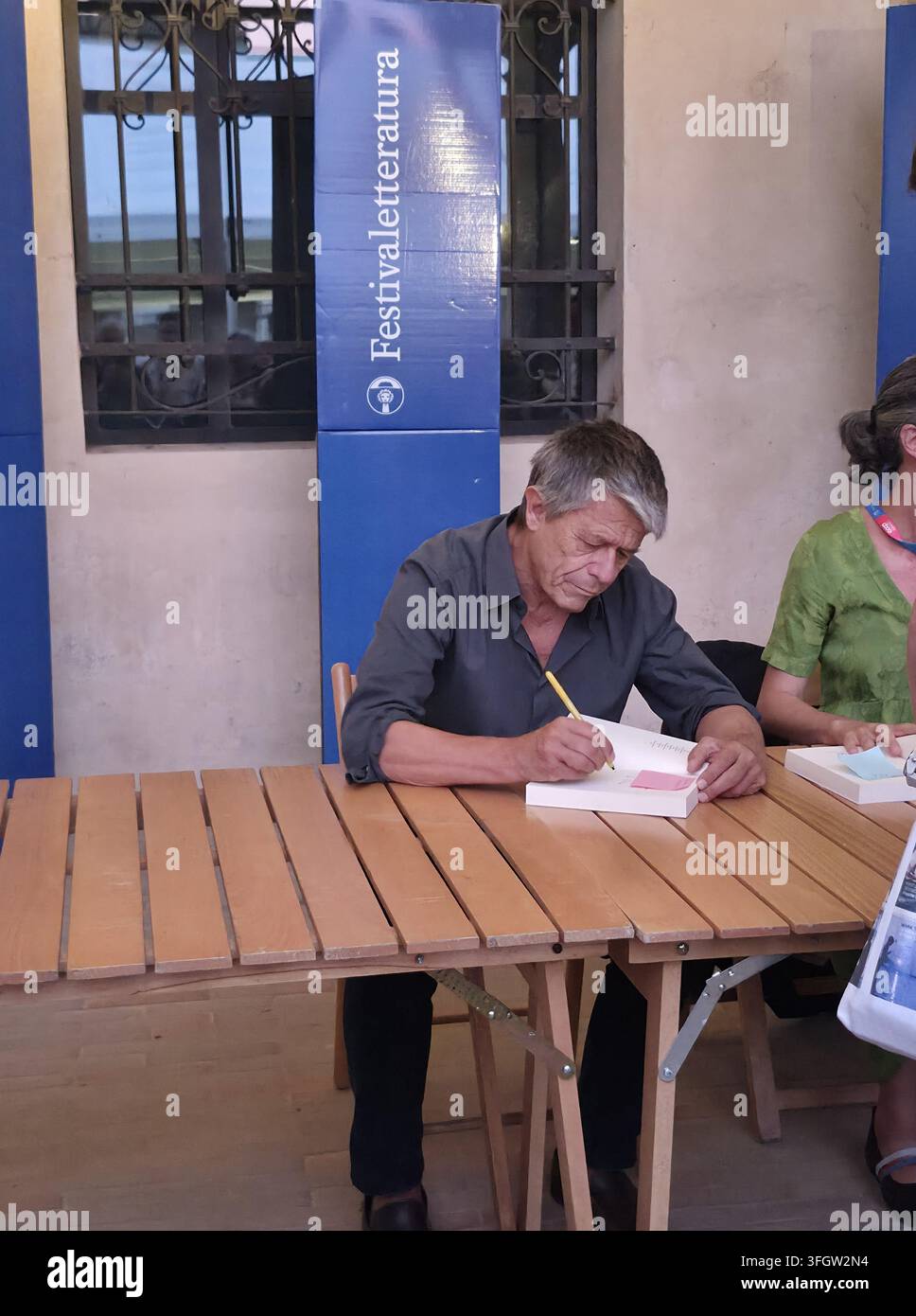 Scrittore francese Emmanuel Carrère autografa copie dei suoi libri per i fan durante una sessione di autografi dedicata al Festivaletteratura. Foto Stock