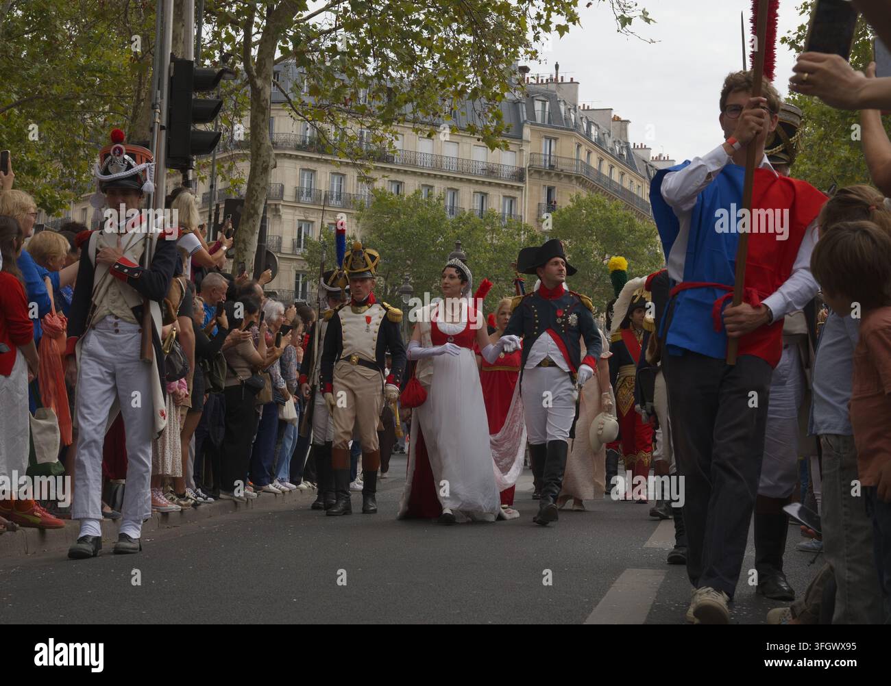 Rinascimentisti storici in uniformi militari dell'era napoleonica e abiti del Primo Impero che sfilano durante una parata storica di strada a Parigi, Francia. Foto Stock