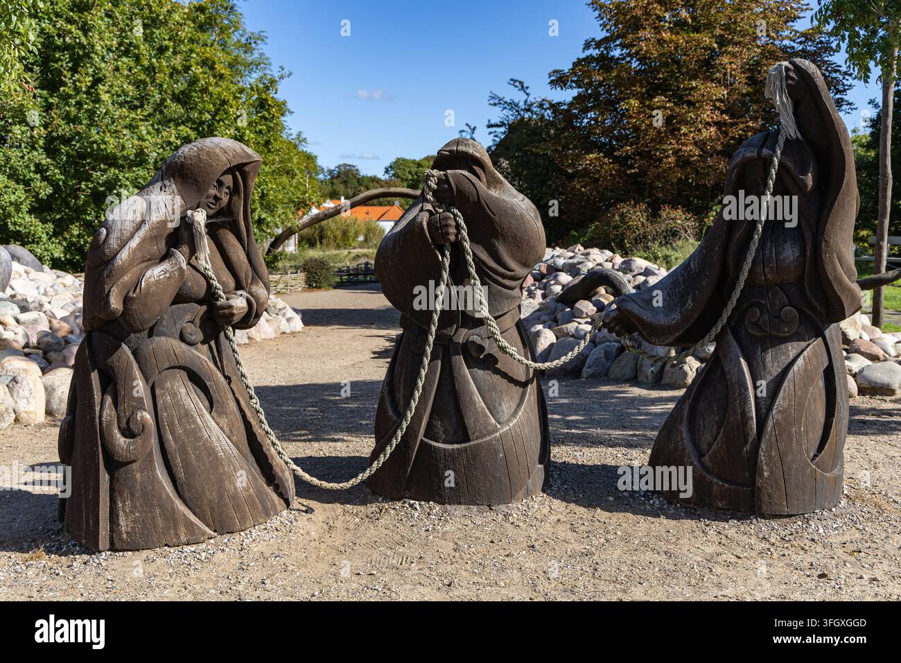 Vista delle sculture in legno delle Norne che tengono una corda al Ribe VikingeCenter di Ribe, Jutland, Danimarca. Foto Stock