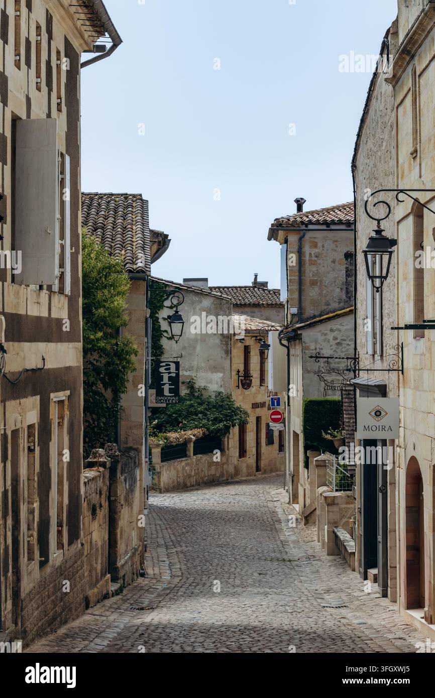 Saint Emilion, Francia - 11 luglio 2026: Strada storica acciottolata con la galleria Art Diagonale e edifici tradizionali in pietra Foto Stock