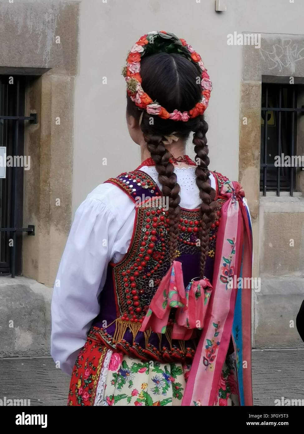 KRAKOW, POLONIA - 15 SETTEMBRE 2022: Donna in abito tradizionale polacco con copricapo floreale nella vecchia città di Cracovia. Foto Stock
