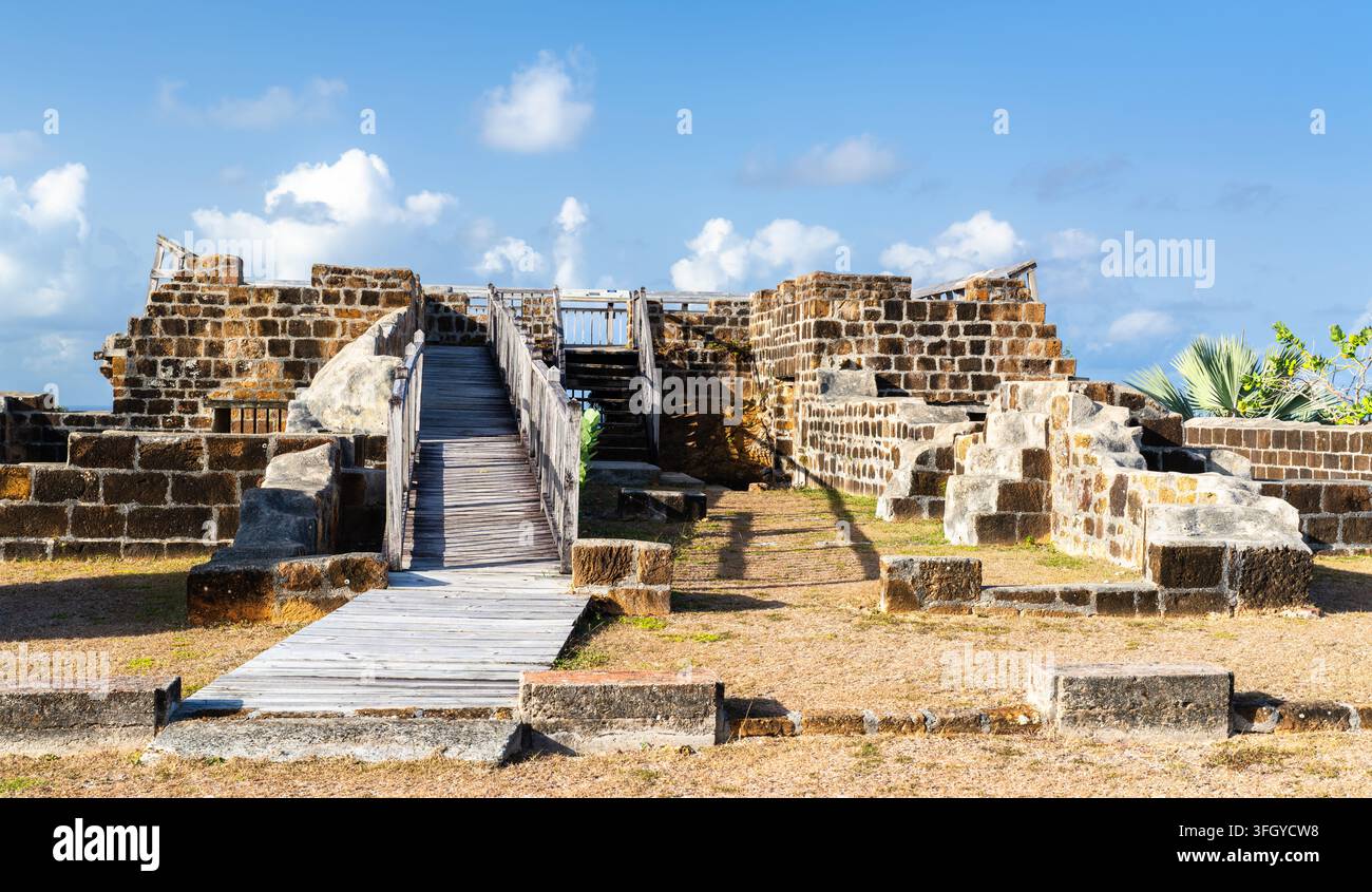 Rovine storiche di fortificazione in pietra e passerella di osservazione in legno al centro di interpretazione di Dows Hill ad Antigua. Foto Stock