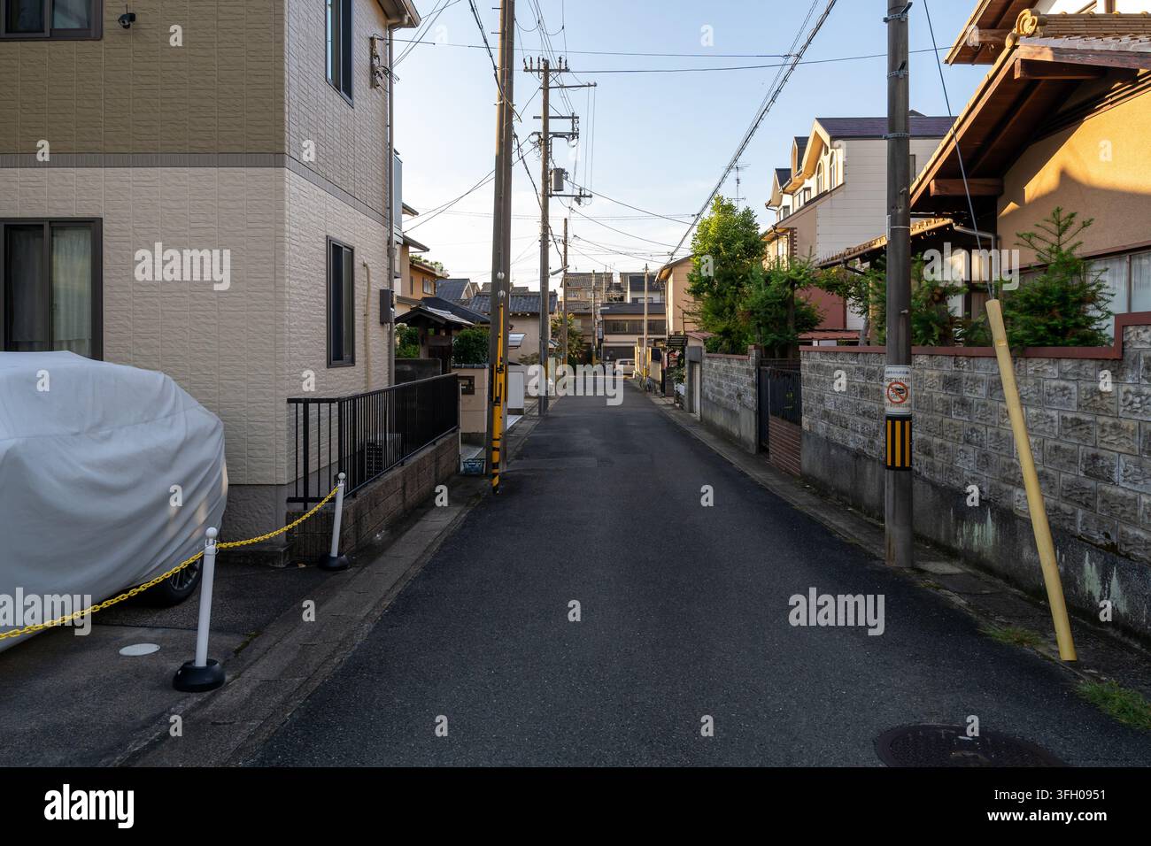 Stretta strada residenziale con pali della luce e case a Kyoto Foto Stock