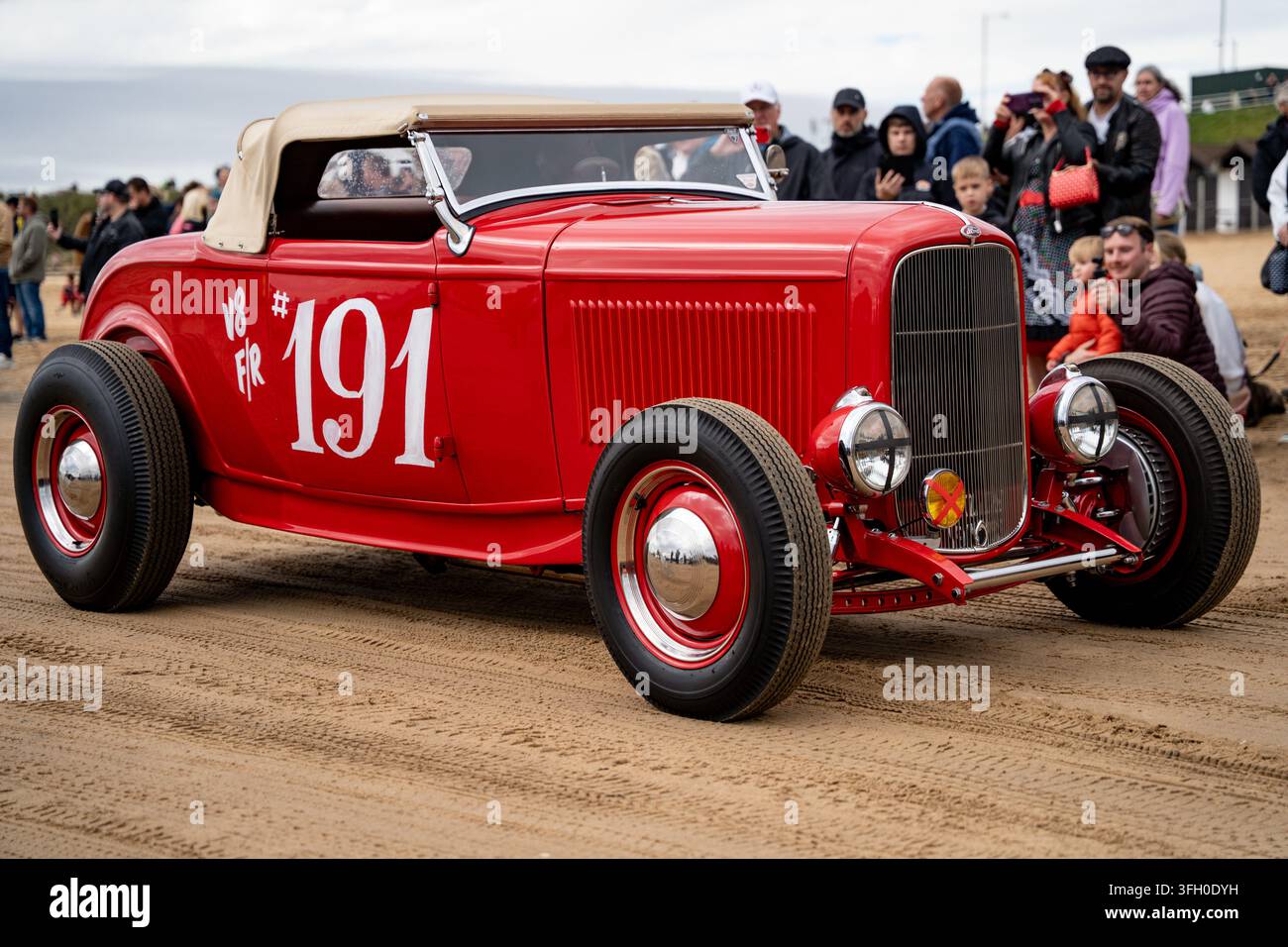 Hot rod rossa numero 191 sulla spiaggia sud di Bridlington durante la Race to the Waves 2026, folle che osservano dietro Foto Stock