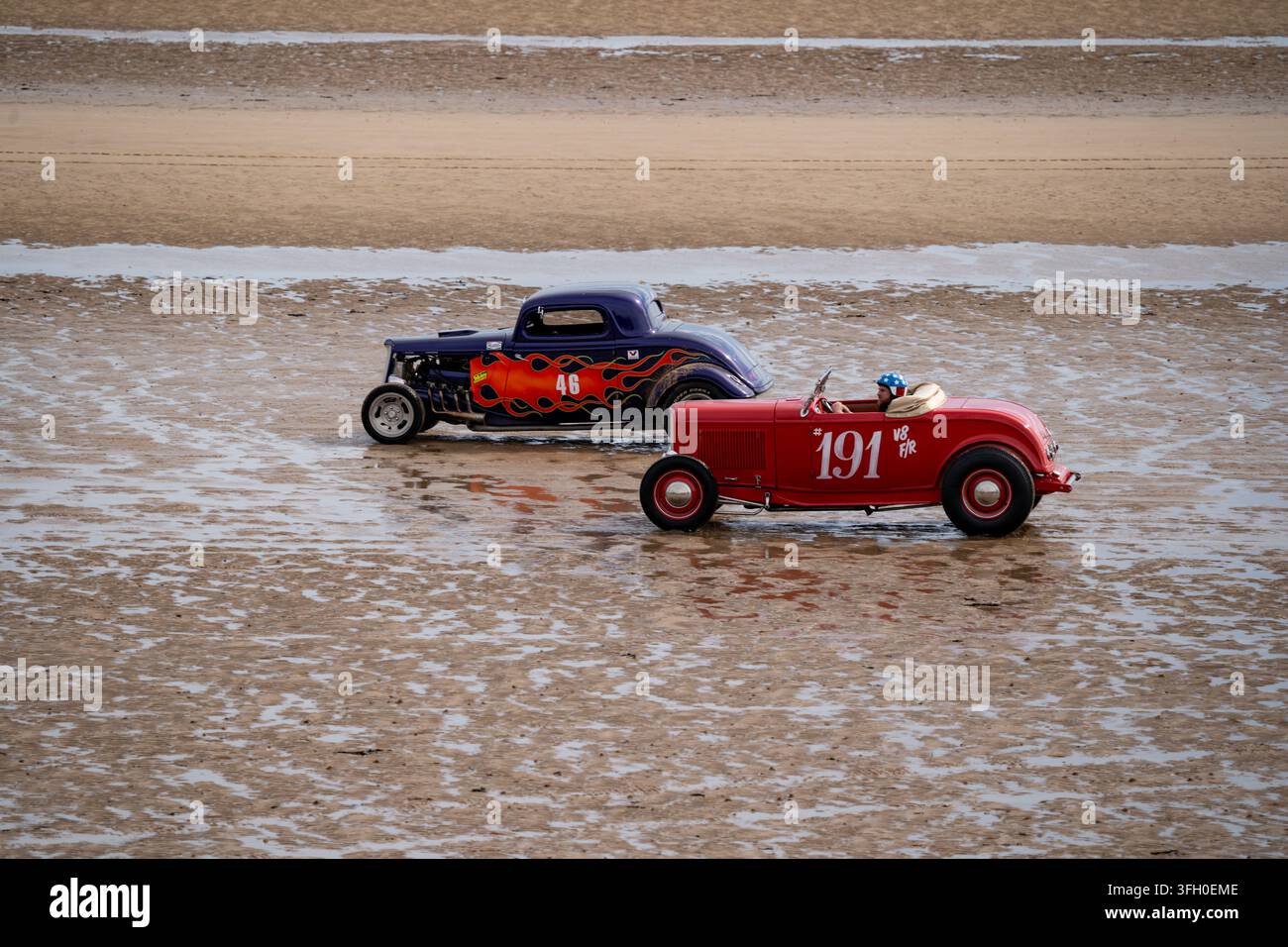 Due hot rod corrono sul sabbia bagnata al Race to the Waves 2026, Bridlington South Beach, East Yorkshire. Foto Stock