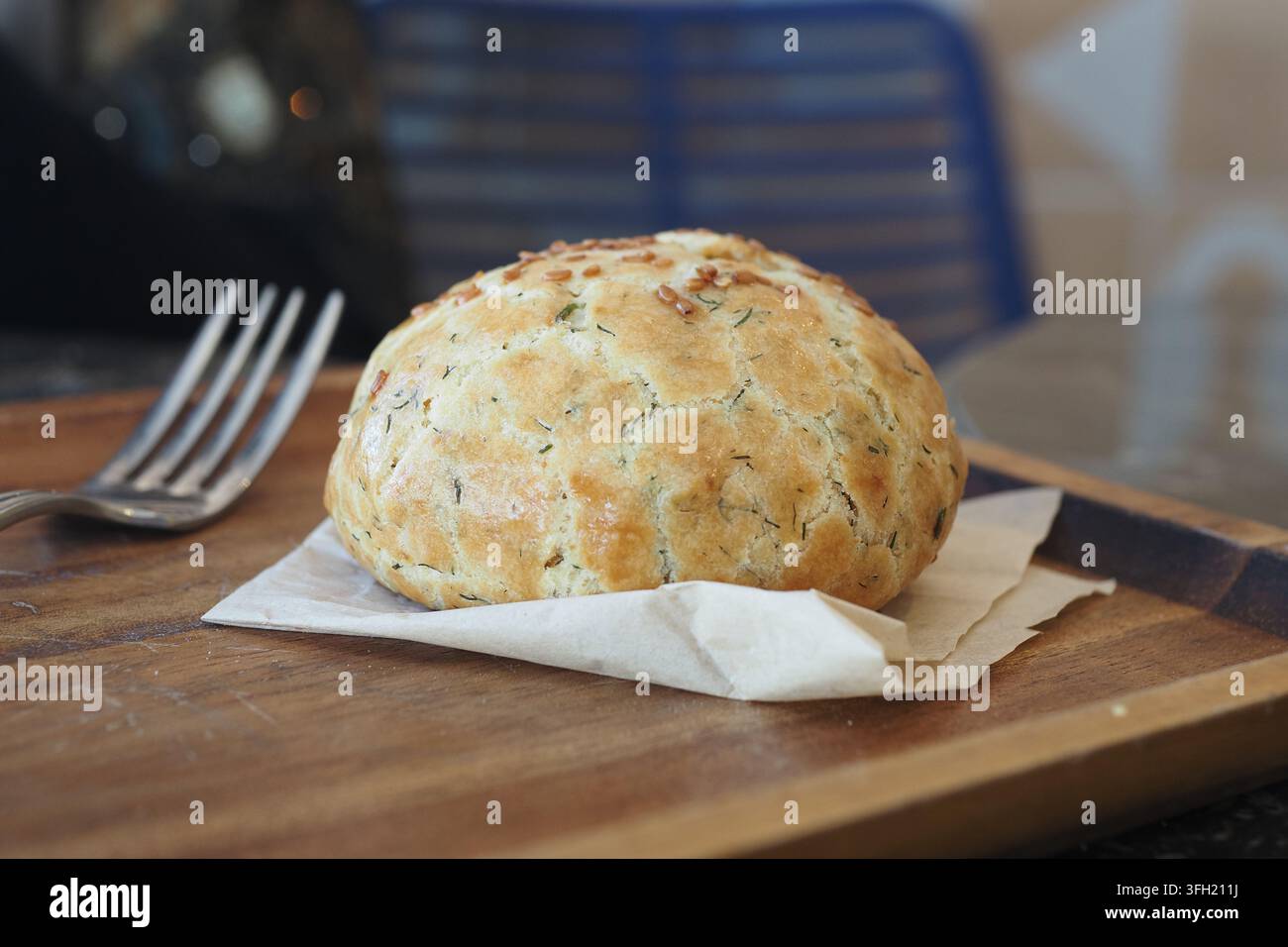 Panino cotto al forno servito su una tavola di legno con una forchetta accanto Foto Stock