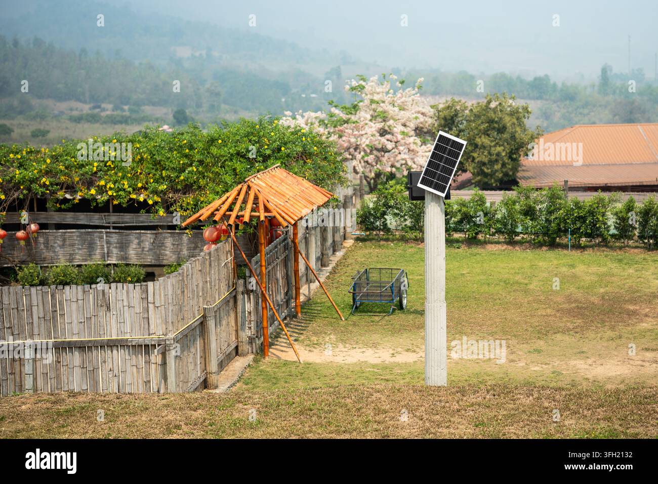 Energia solare ecologica economica in una fattoria rurale, piccolo pannello solare montato su un palo in campagna. Foto Stock