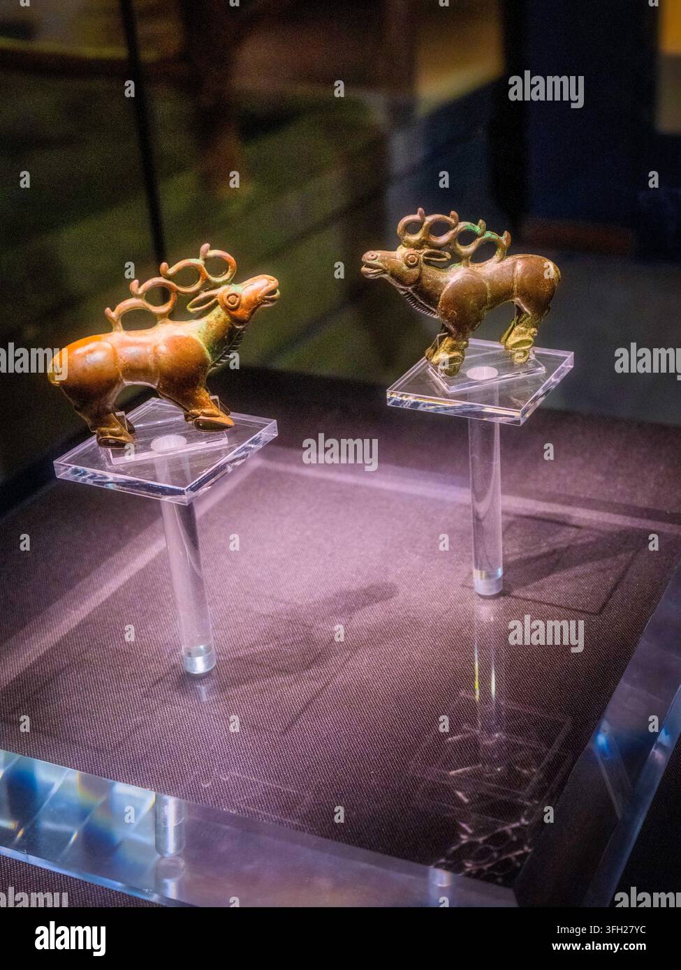 Una coppia di antiche sculture in bronzo di alci esposte al Museo di Zhangye nel Gansu, Cina. Arte in bronzo stile prato primitivo, preziosi reperti scoperti disco Foto Stock