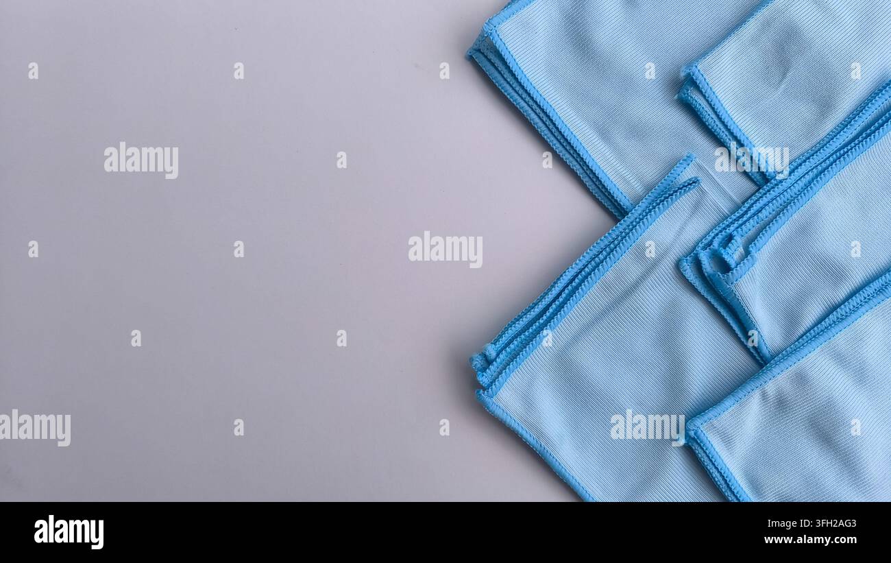 Flat lay orizzontale di stracci blu piegati per la pulizia su una superficie grigia neutra. - Immagine stock catturata con smartphone