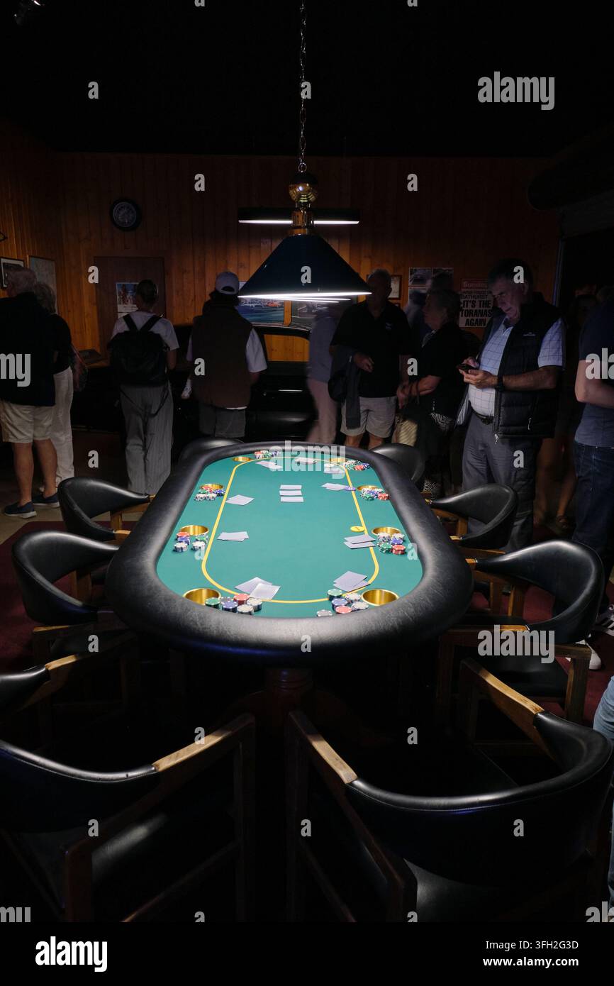 Persone in un'installazione che è la ricreazione di una sala ricreativa del seminterrato con tavolo da carte e tavolo da poker. Al MONA, Museum of Old and New vicino a Hobart, Australia. Foto Stock