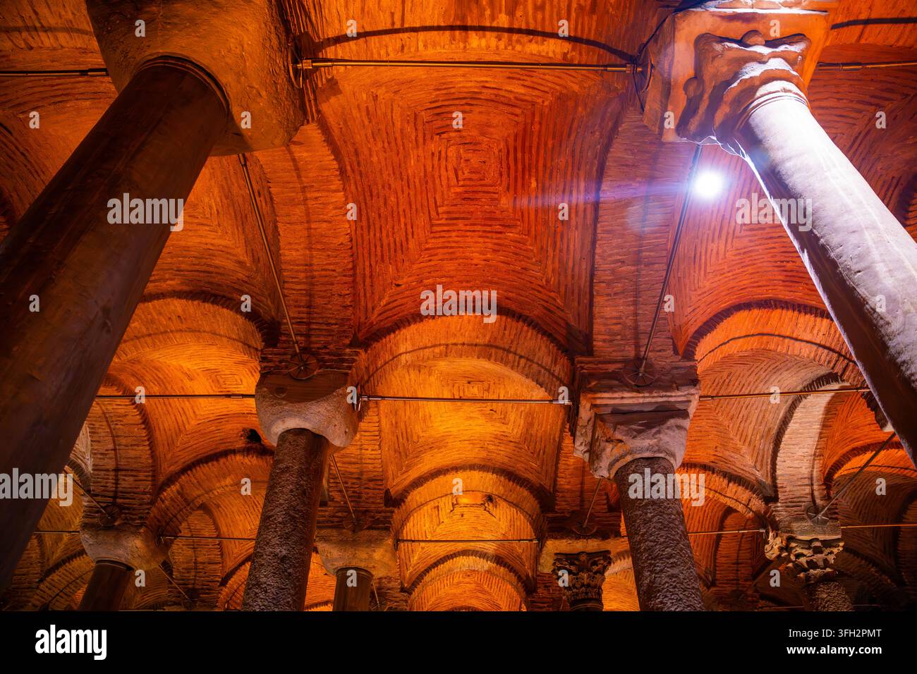 Interno architettonico della Cisterna Basilica a Istanbul, con file di colonne e soffitti a volta illuminati da una luce calda Foto Stock