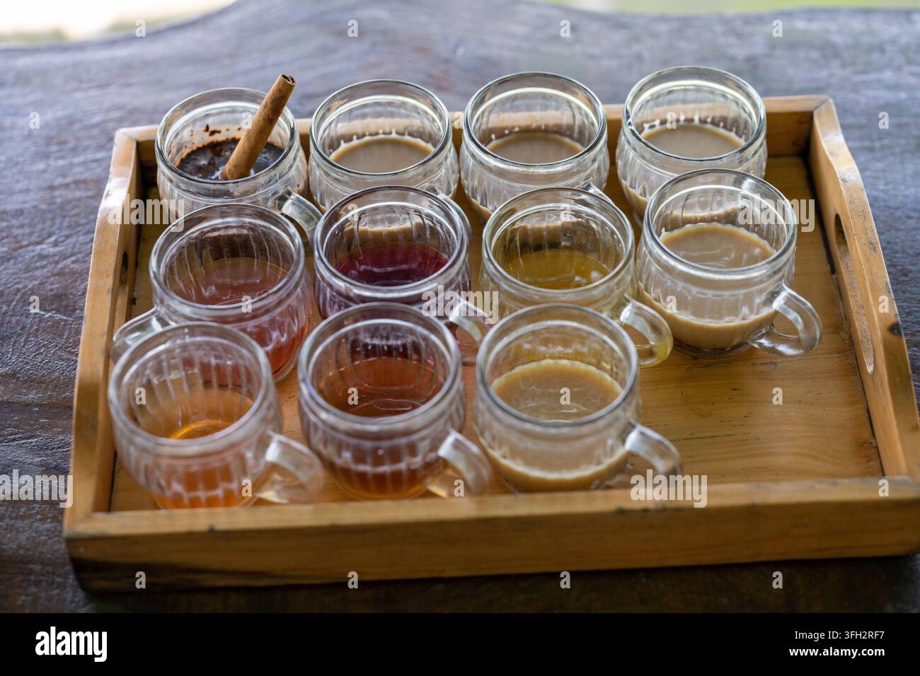 Campioni assortiti di caffè, tè e bevande aromatizzate sono disposti su un vassoio di legno vicino al Monte Batur e al Lago Batur a Bali, Indonesia. Foto Stock