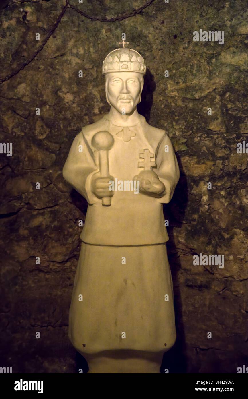 Statua di Santo Stefano I d'Ungheria che raffigura il re con uno scettro e una sfera con una croce, in piedi su uno sfondo di parete rocciosa di grotta ruvida in Foto Stock