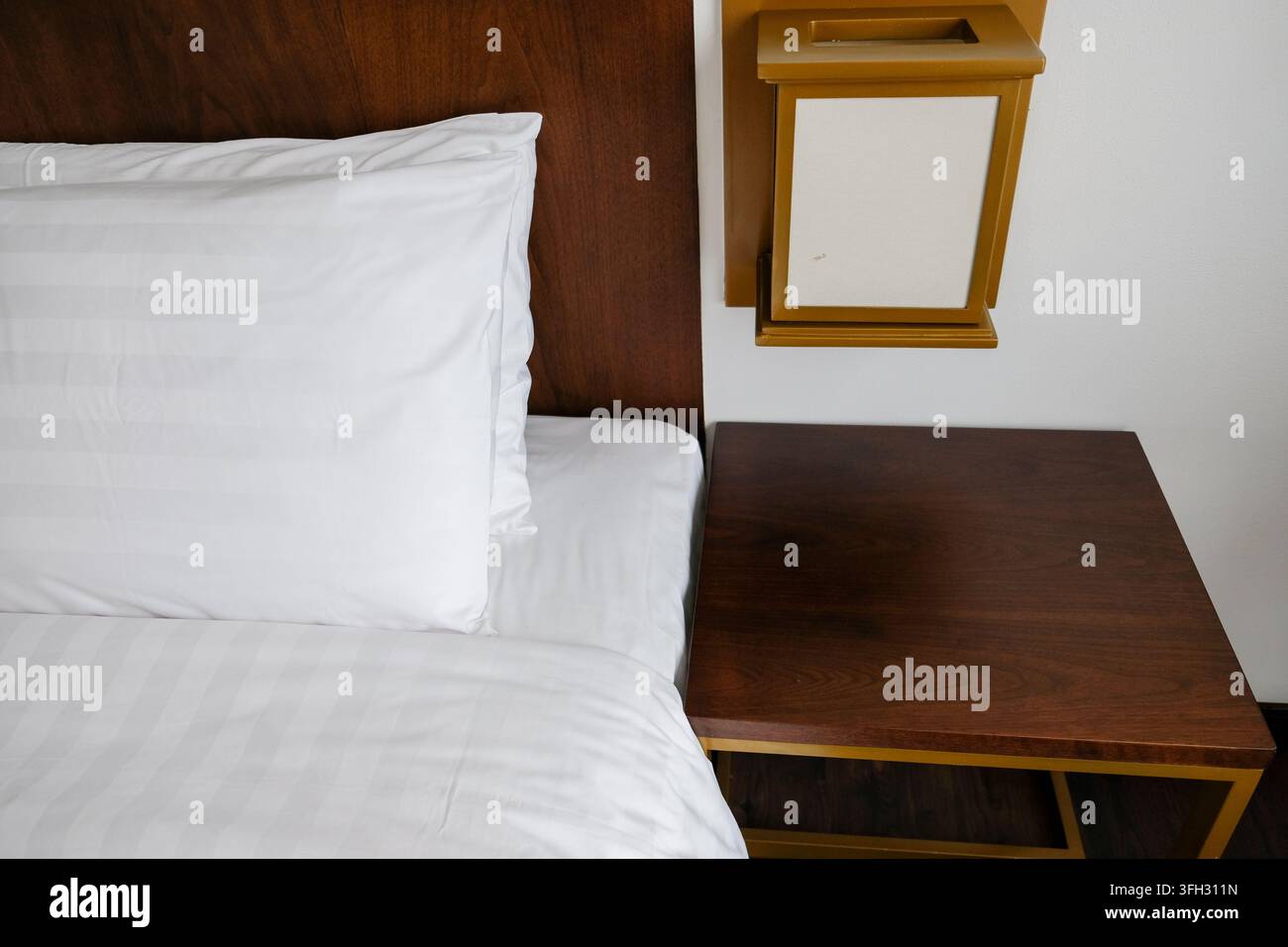 Moderno comodino in legno e tavolo da notte in un interno di camera d'albergo Foto Stock