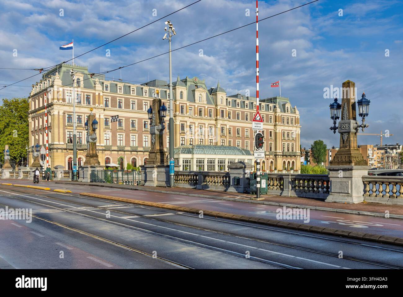 Amsterdam, Paesi Bassi – 28 agosto 2026. Edificio di lusso dell’hotel InterContinental Amstel visto dal ponte sul fiume Amstel con binari del tram Foto Stock