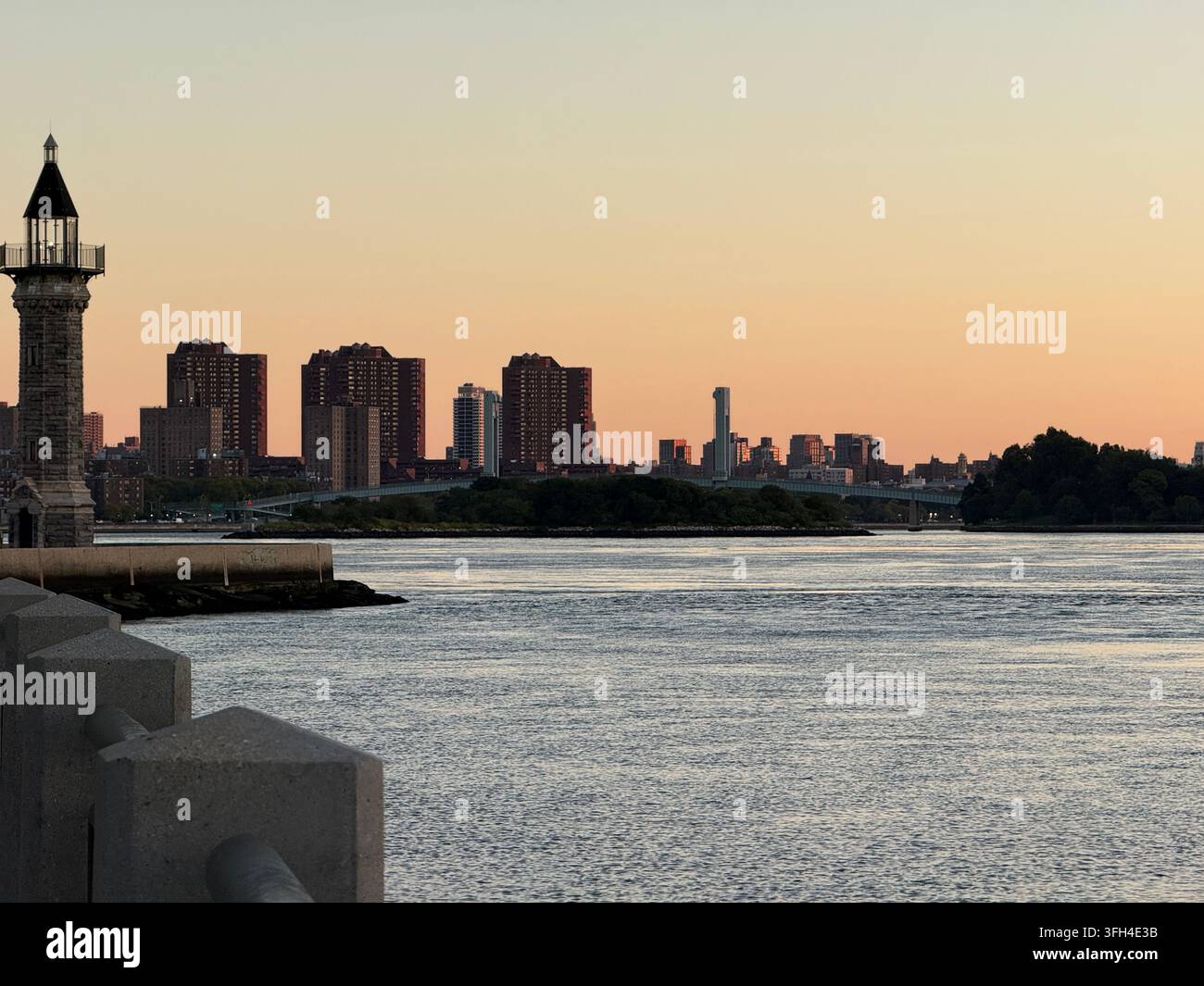 Farro di Blackwell Island all'estremità settentrionale di Roosevelt Island al tramonto, con Mill Rock, il ponte di Wards Island e Upper Manhattan. - Immagine stock catturata con smartphone