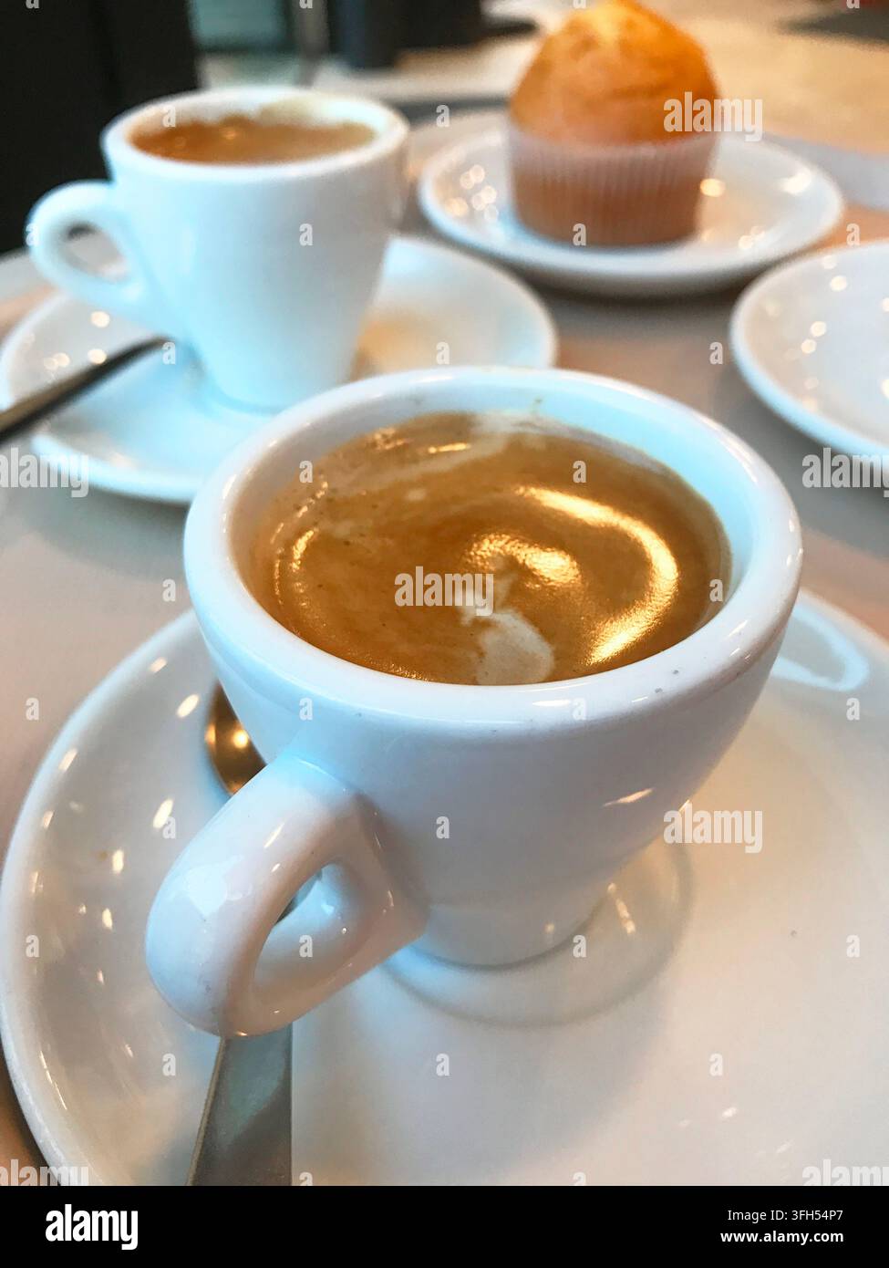 Due tazze di caffè e un muffin per la colazione. Vista ravvicinata. Foto Stock