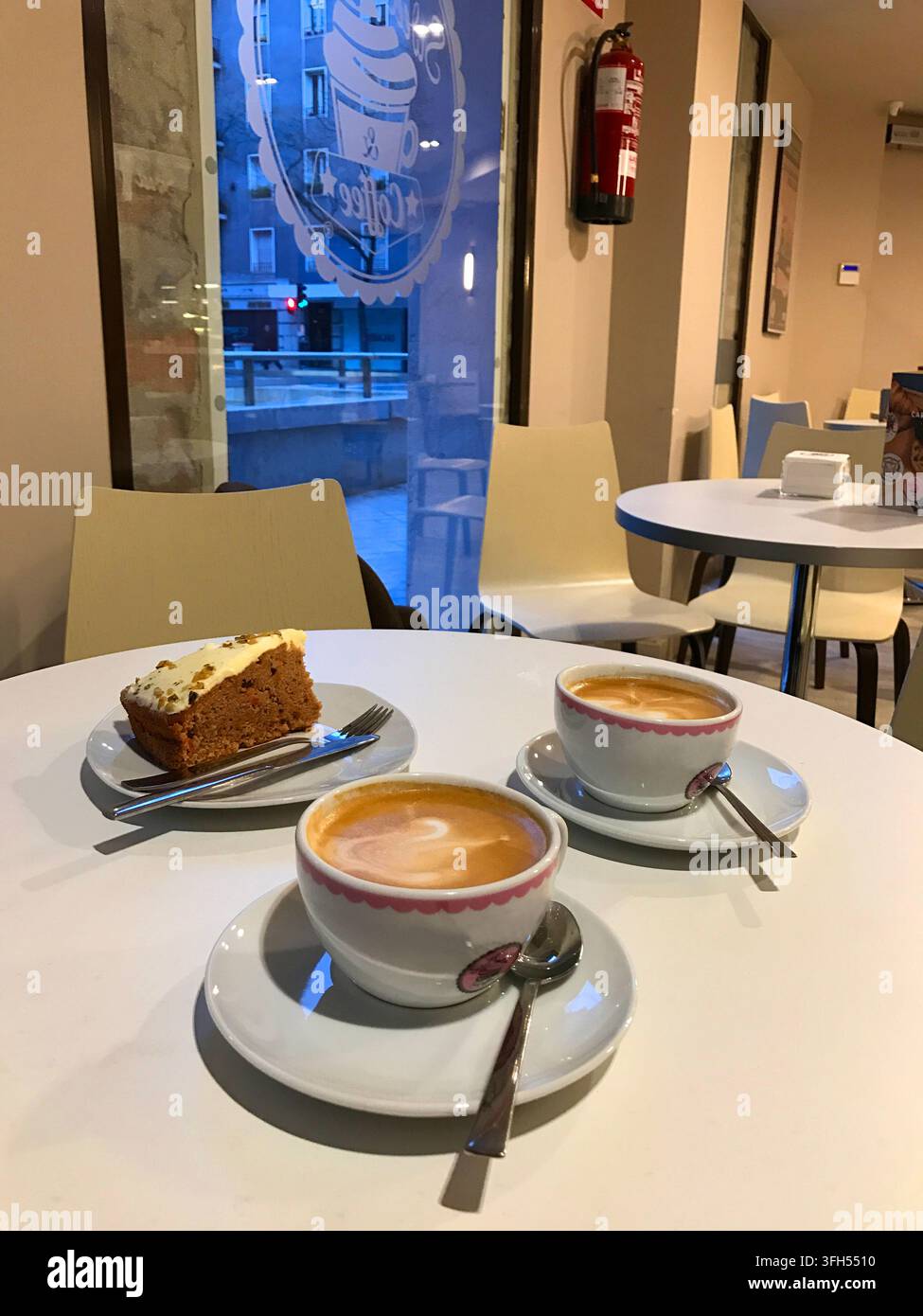 Due tazze di caffè con torta in un caffè. Madrid, Spagna. Foto Stock