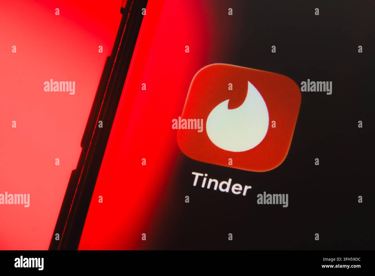 Parigi, Francia - 15 settembre 2026: Logo dell'applicazione di incontri Tinder su uno schermo smartphone con illuminazione al neon rossa. Foto Stock