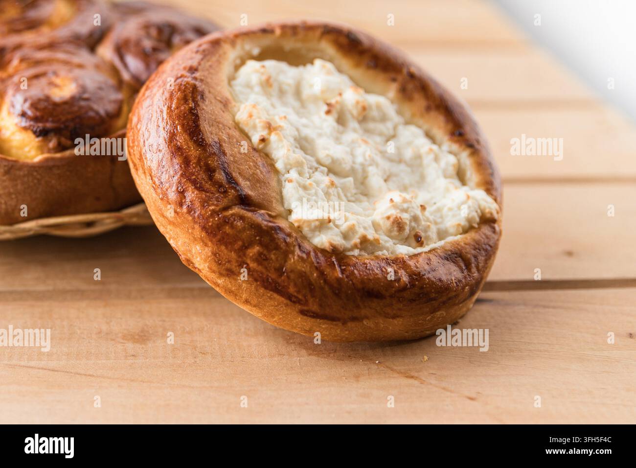 Pasticceria tradizionale al formaggio di cottage con crosta dorata su tavolo di legno Foto Stock
