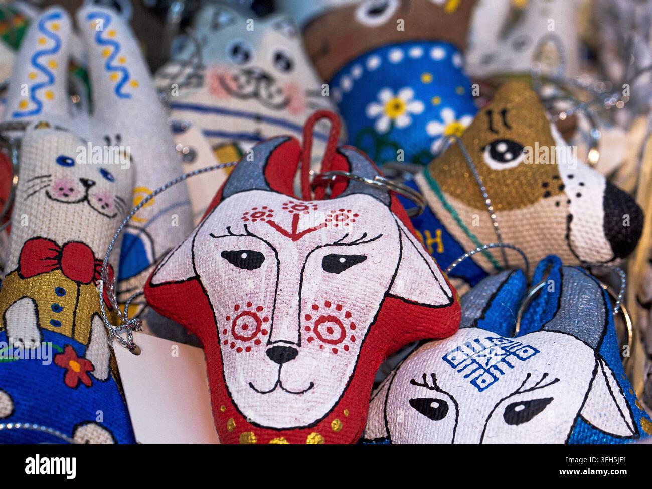 Primo piano di figure animali tessili realizzate a mano con volti ricamati in stile folkloristico e colori vivaci, esposti in una mostra artigianale festiva. Foto Stock
