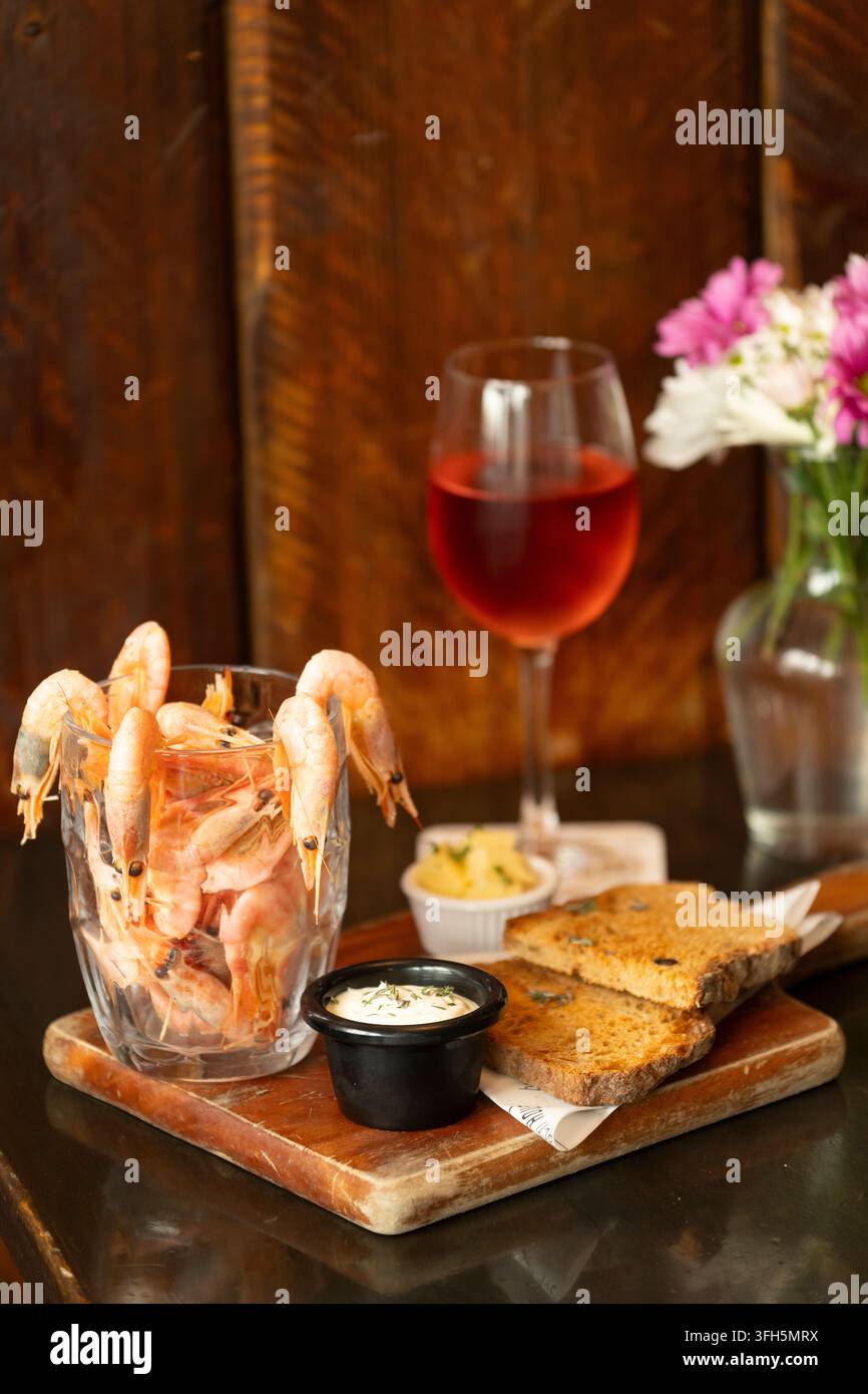 Piatto di frutti di mare delizioso con bevanda rinfrescante in un ambiente da pranzo accogliente Foto Stock