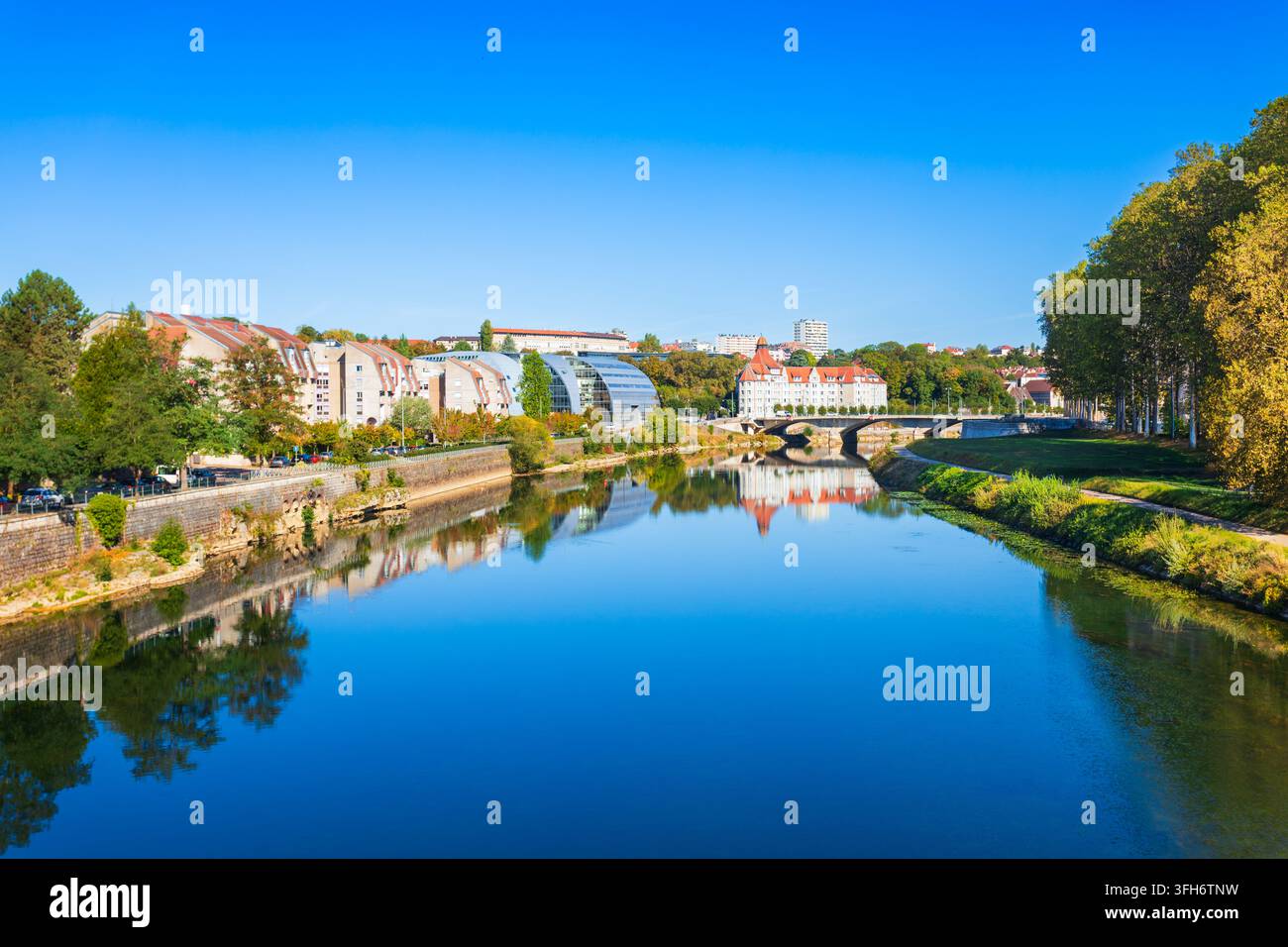 Riflesso acquatico scenografico di edifici moderni e storici sulla riva del Doubs a Besançon, Francia Foto Stock