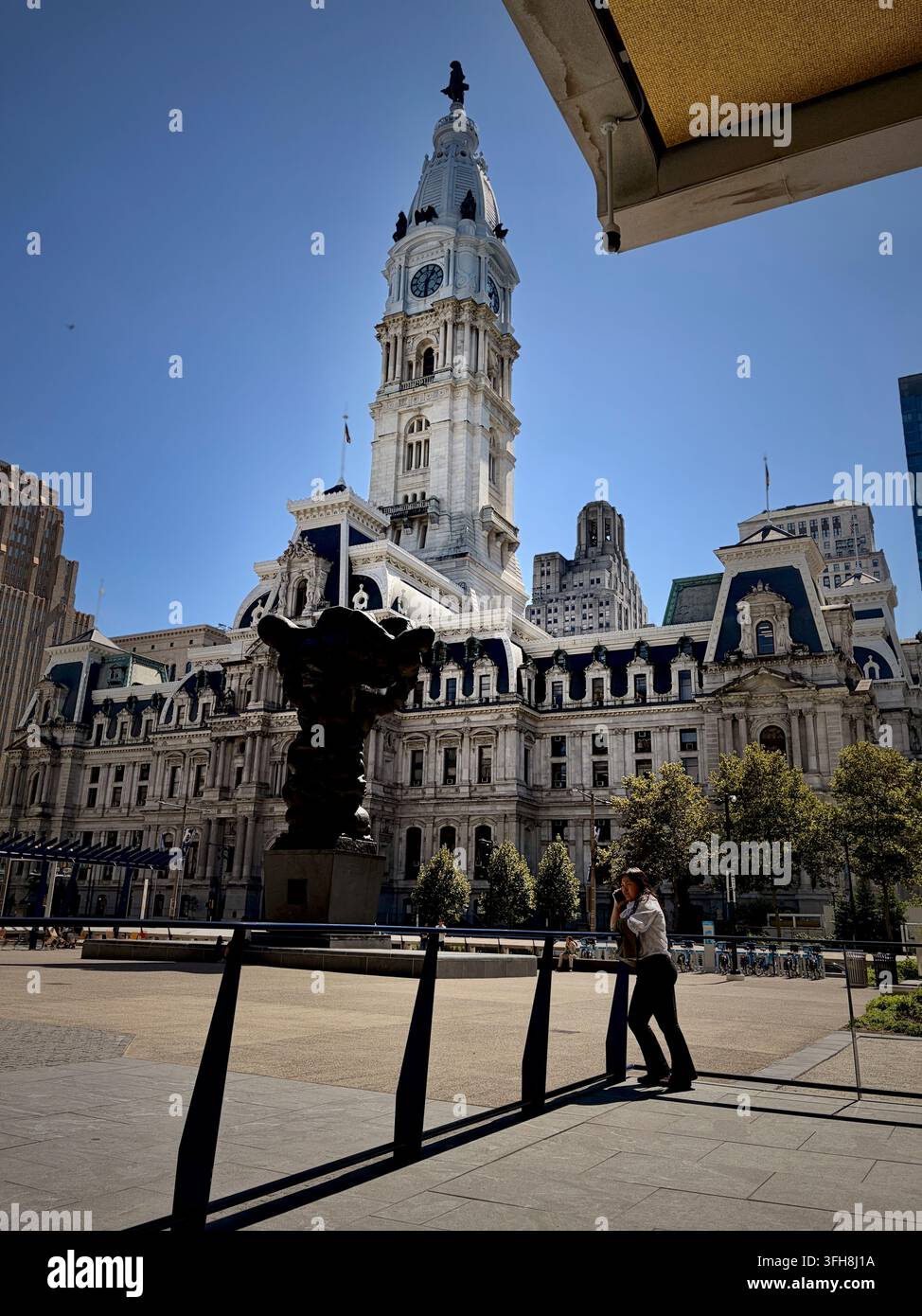 Filadelfia, PA, USA – 15 settembre 2026: Una persona fa una telefonata a Thomas Pain Plaza, di fronte al municipio di Filadelfia. - Immagine stock catturata con smartphone