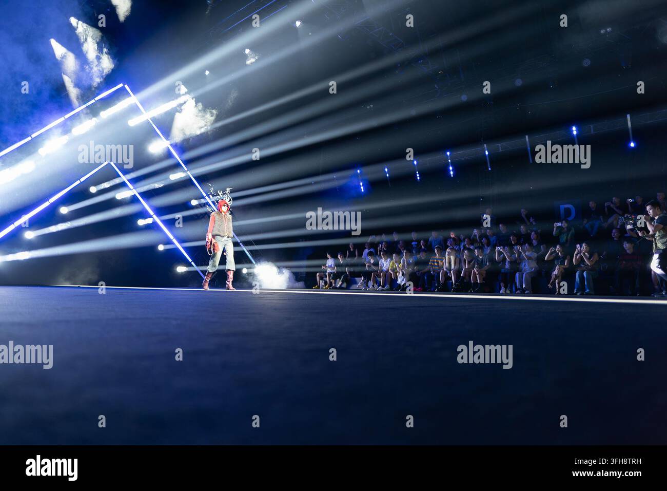 Guangzhou, Cina – 15 settembre 2026: Una modella sfila sotto le luci di scena durante la Guangdong Fashion Week. Foto Stock