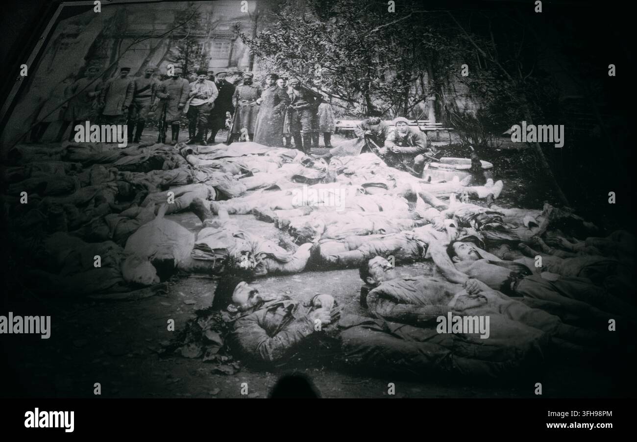 Combattenti comunisti in posa davanti ai corpi delle persone giustiziate a Tiflis, Occupazione sovietica della Georgia. Uomini armati in piedi dietro le vittime di un massacro di massa Foto Stock
